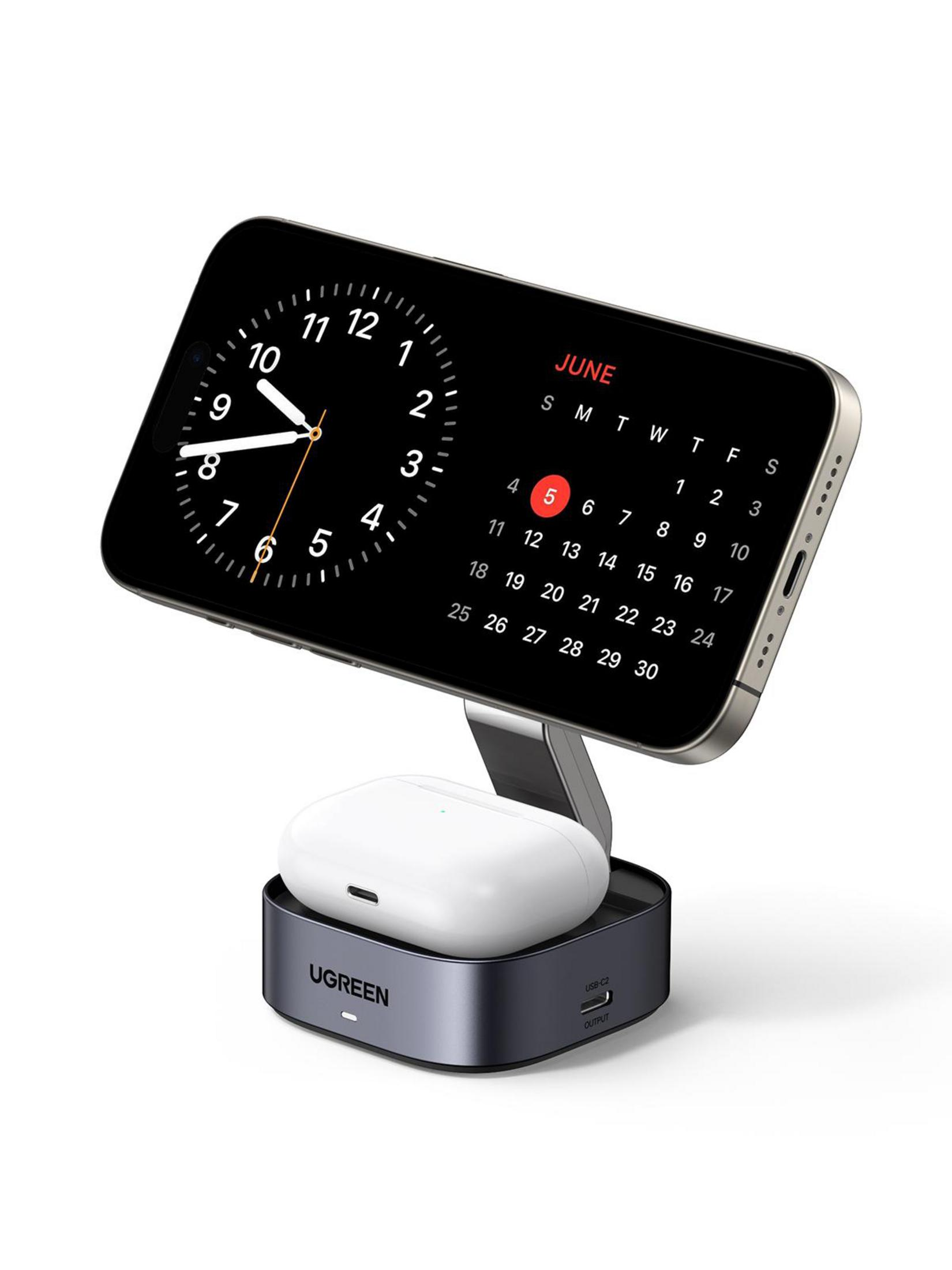 Stojak do ładowania bezprzewodowego UGREEN z telefonem wyświetlającym zegar i kalendarz oraz słuchawkami na podstawie.