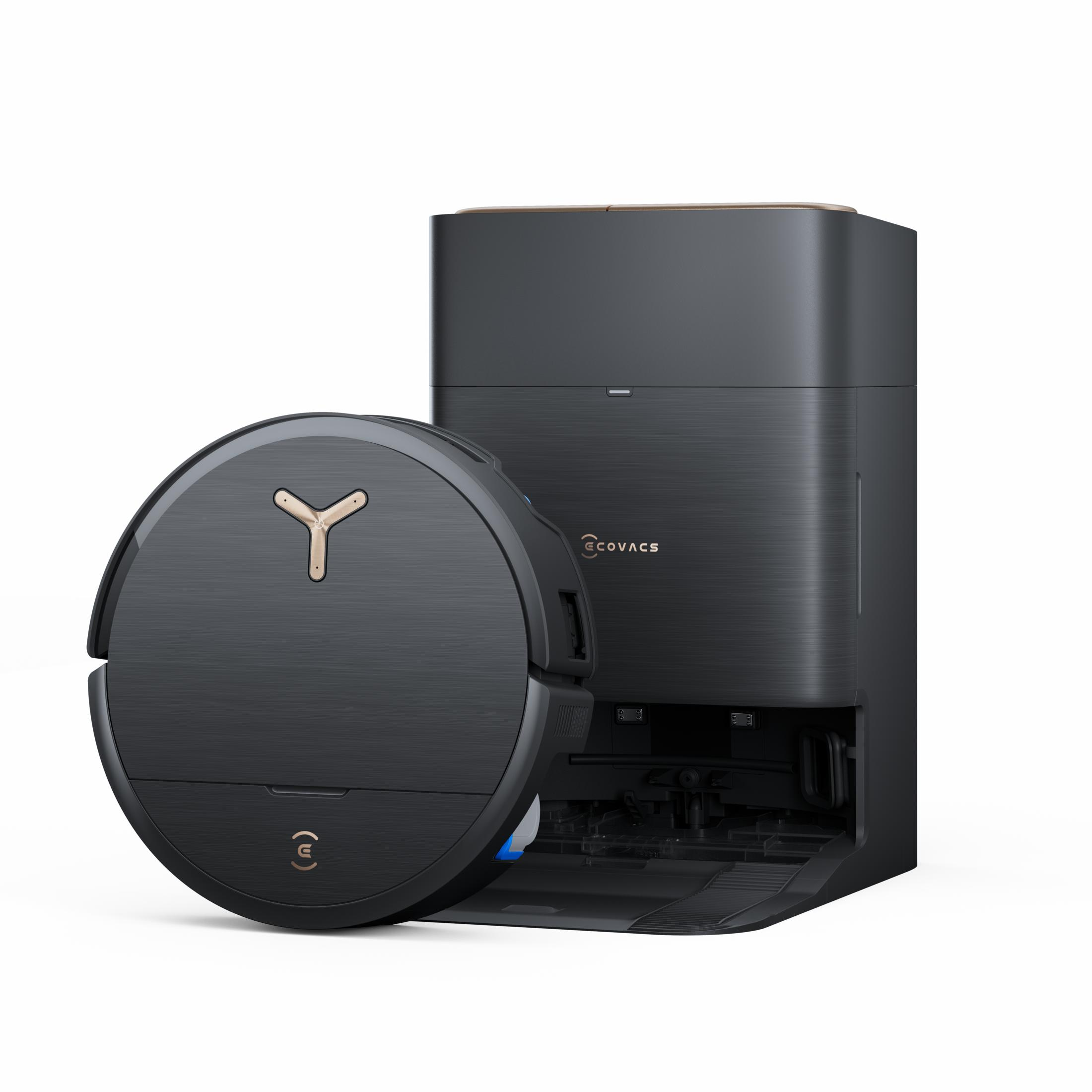 Ein schwarzer Roboterstaubsauger und eine Basisstation mit goldenen Akzenten, die auf einer weißen Oberfläche stehen.