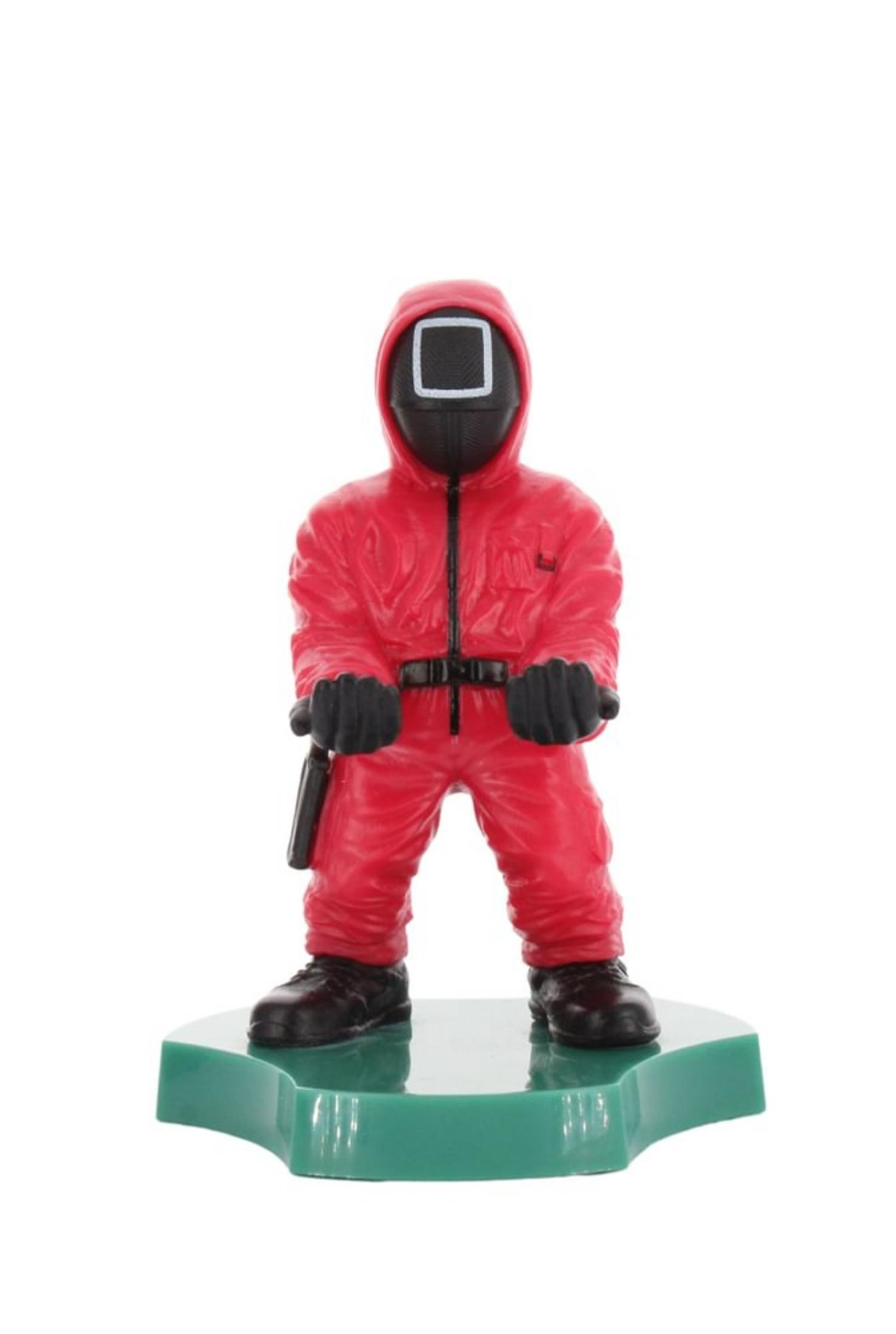 Eine Squid Game Masked Manager-Figur in einem roten Anzug, die auf einem grünen Sockel steht und die Hände ausstreckt.