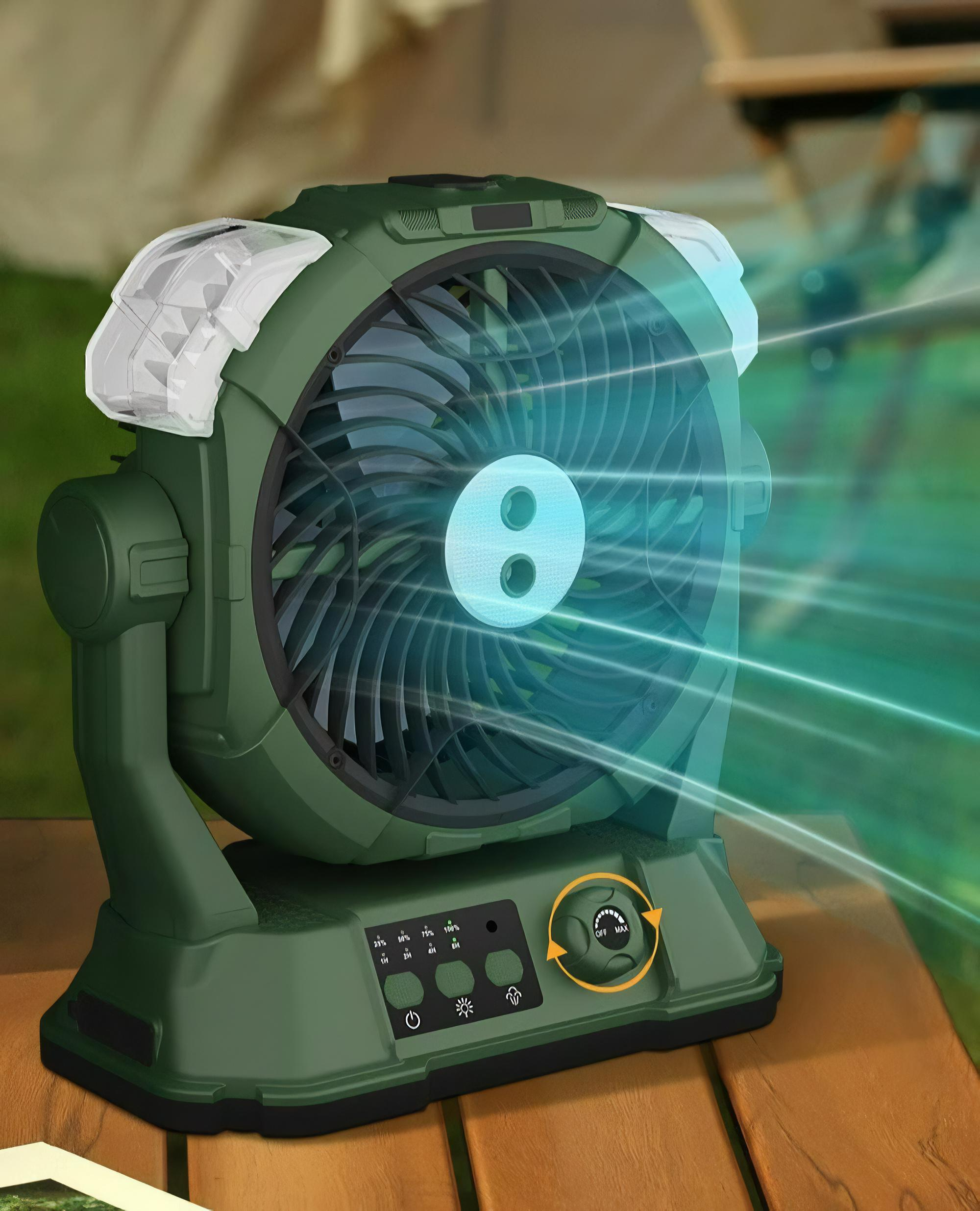 Grüner Campingventilator mit Lichtern auf einem Holztisch im Freien. Die Lüfterflügel sind sichtbar.