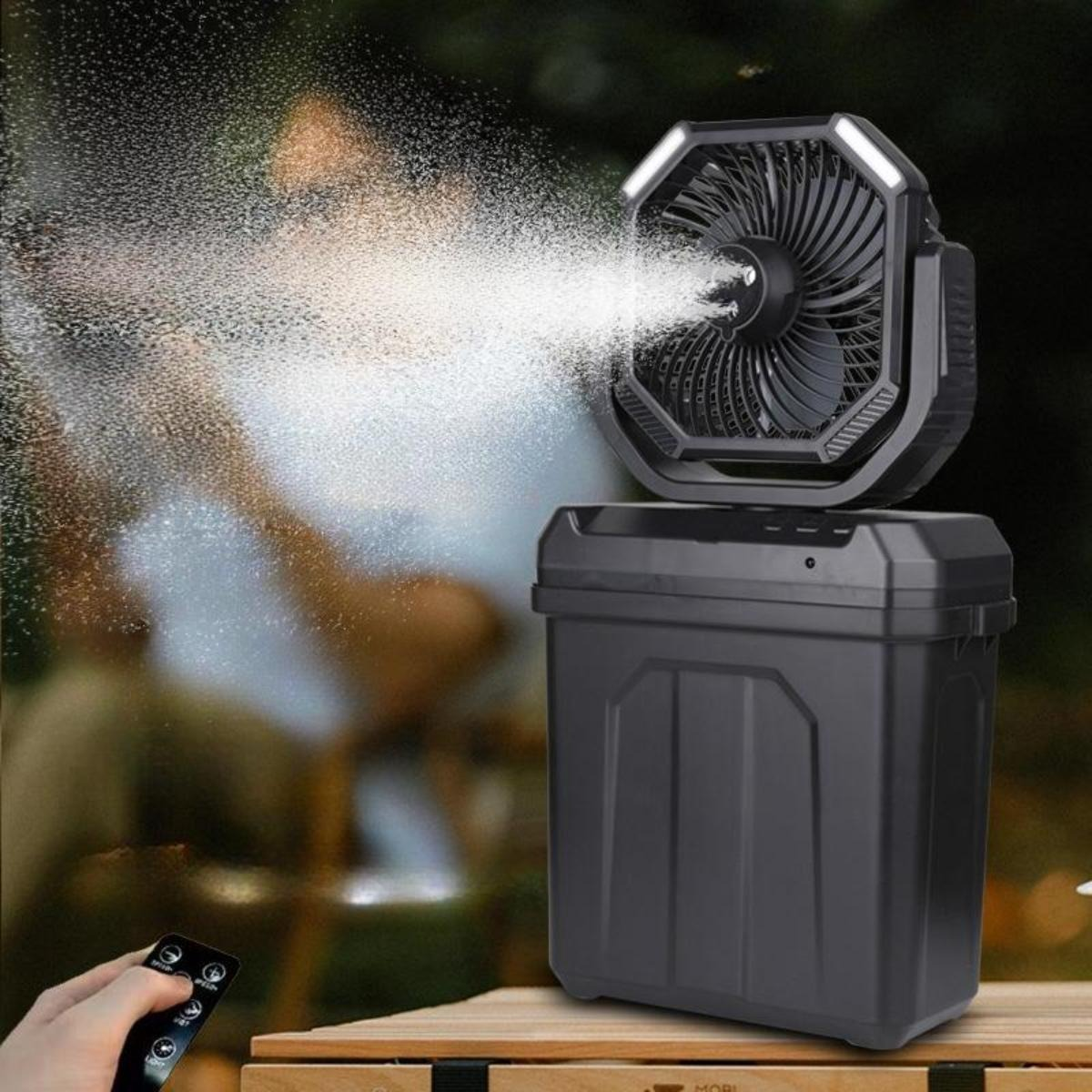 Ein schwarzer tragbarer Ventilator mit Lichtern sprüht Nebel, mit einer verschwommenen Figur im Hintergrund.