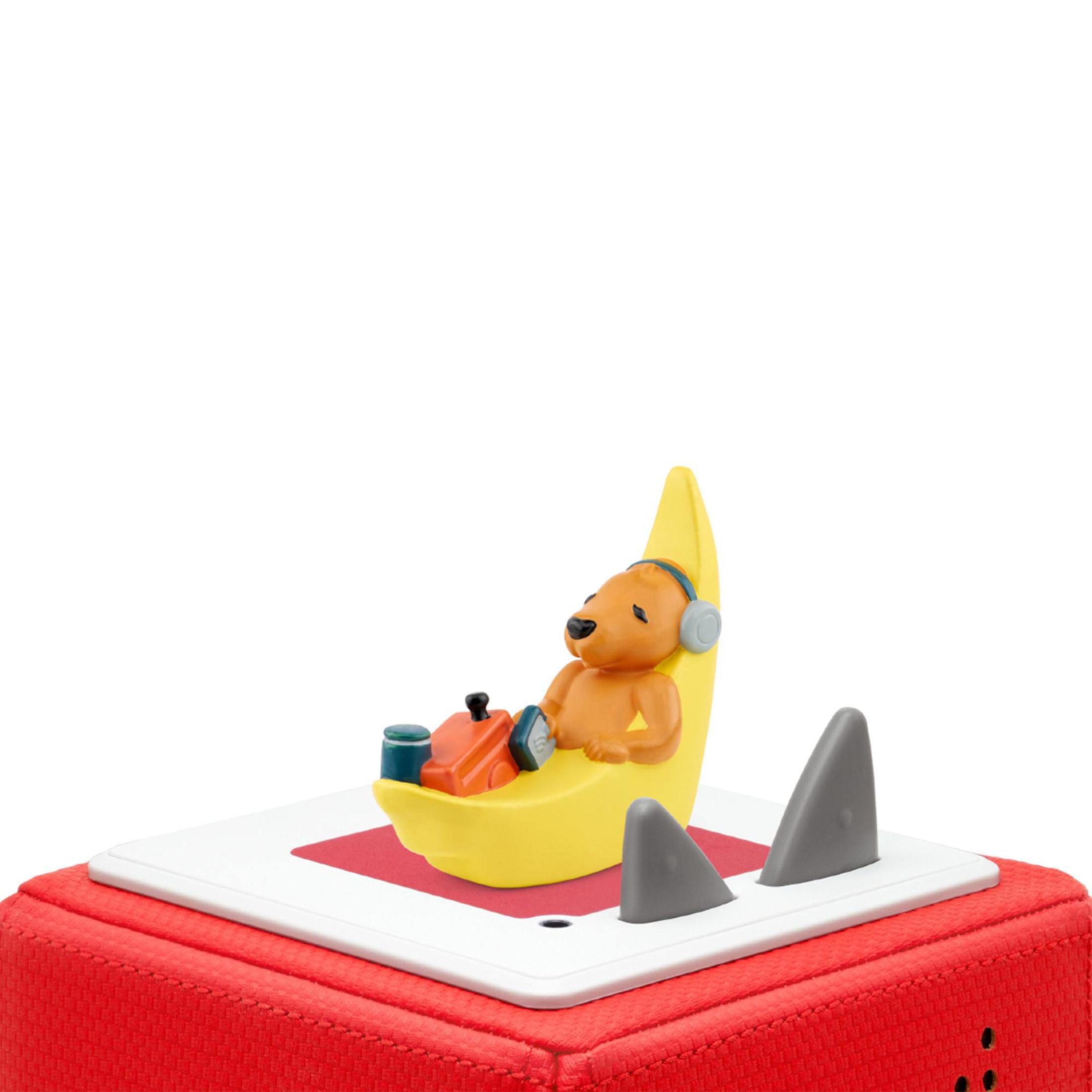 Ein Spielzeugbär mit Kopfhörern auf einem gelben Halbmond auf einer roten und weißen Toniebox.