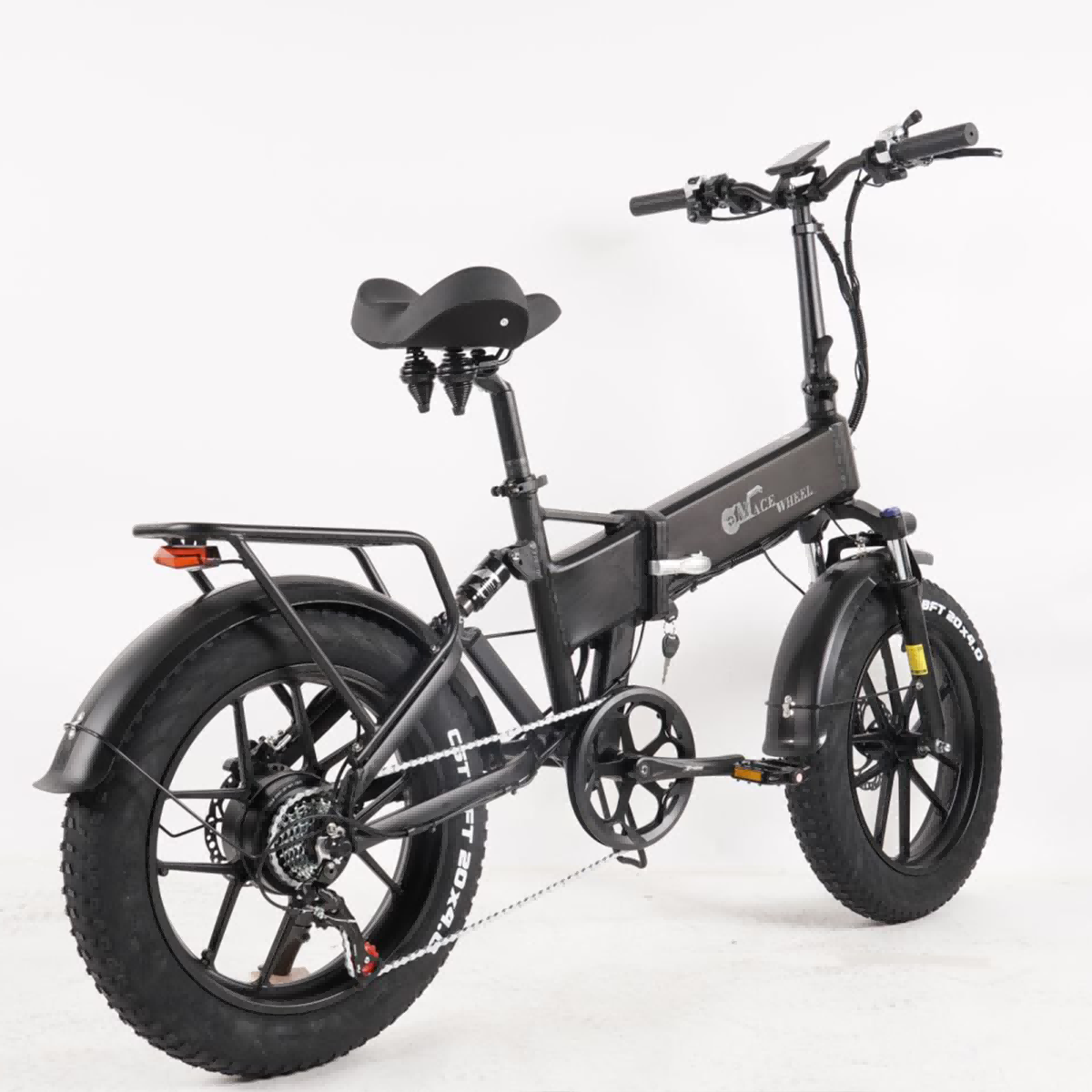 Czarny rower elektryczny z grubymi oponami na białym tle. Rower ma tylny bagażnik, tylne światło i klucz.