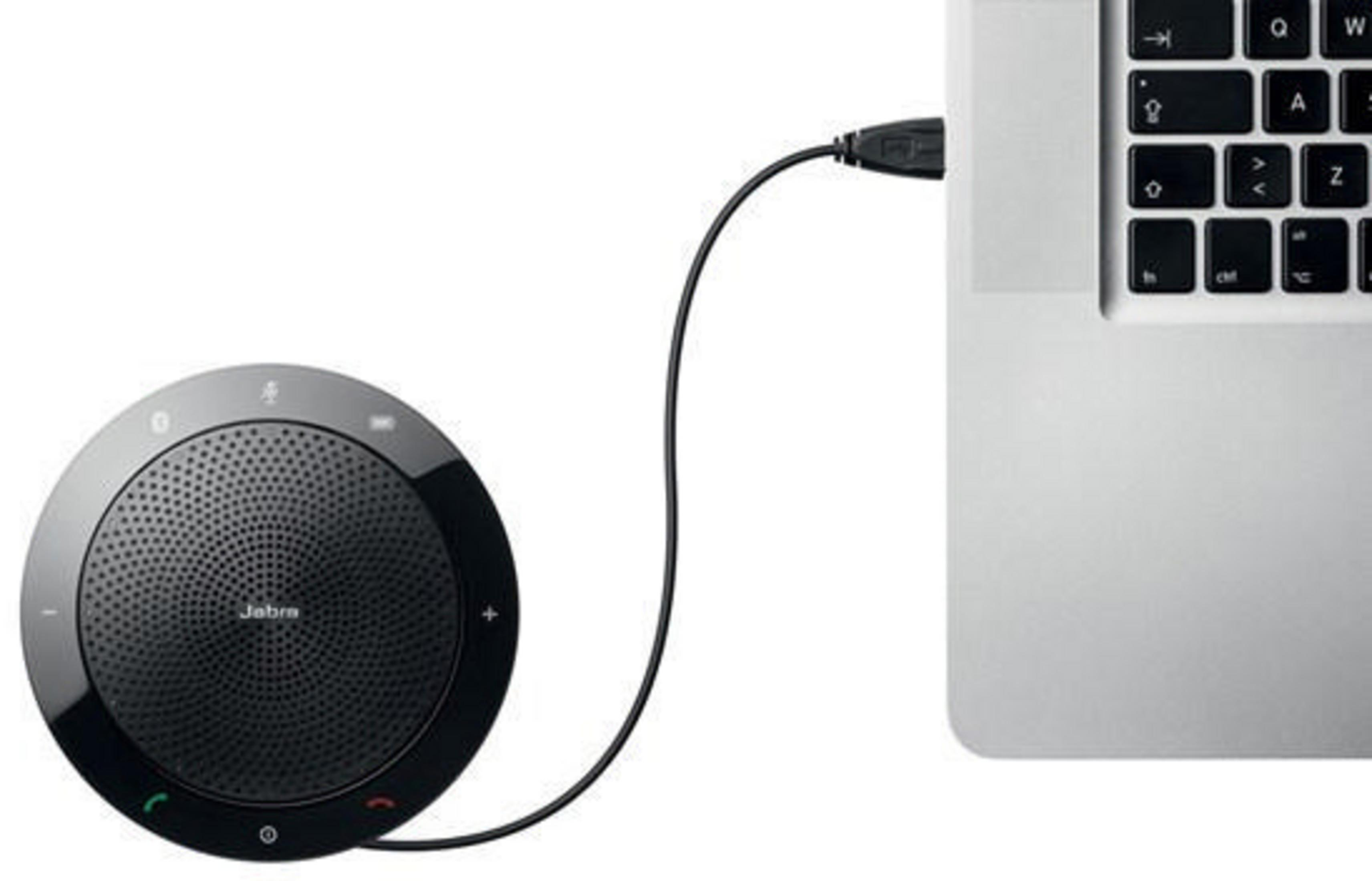 Schwarzer Jabra-Lautsprecher per USB mit einem Laptop verbunden, der ein typisches Büro- oder Heimsetup veranschaulicht.