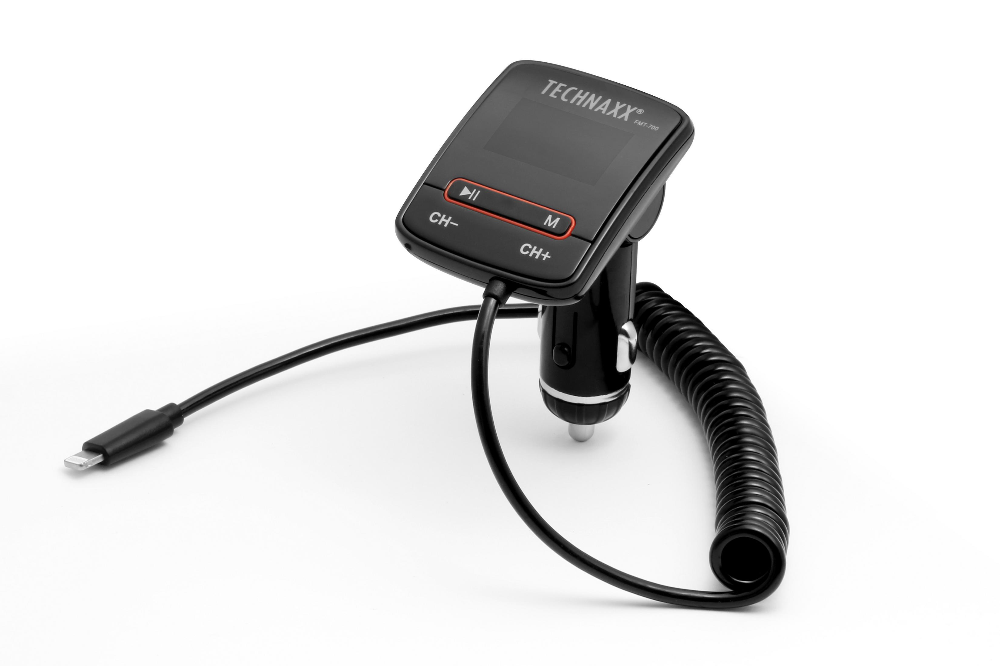 Un trasmettitore FM Technaxx nero con display e cavo di ricarica, su una superficie bianca. Il cavo è arrotolato.