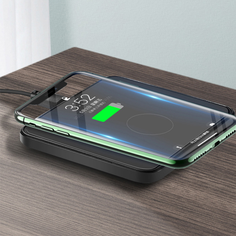 Ein Telefon, das auf einem schwarzen kabellosen Ladegerät aufgeladen wird. Der Telefonbildschirm zeigt die Zeit und das Aufladen des Akkus an.