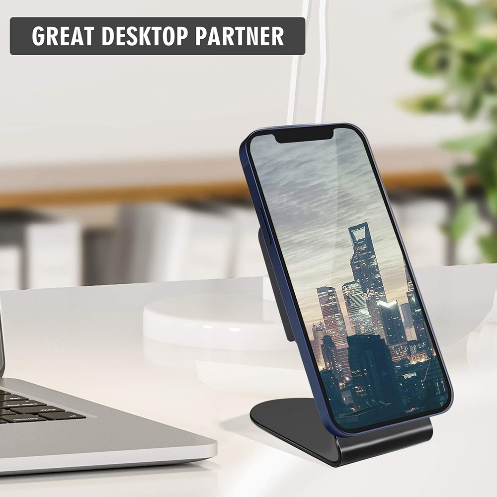 Telefon auf Ständer zeigt Stadtszene, Laptop auf weißem Schreibtisch, Text lautet 'Great Desktop Partner'.