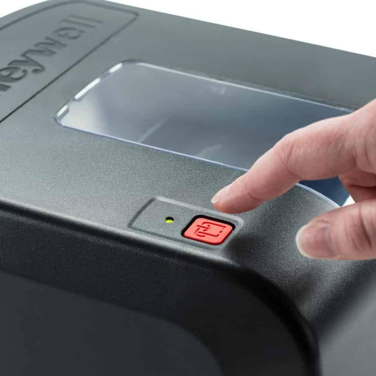 Bir parmak, bir Honeywell etiket yazıcısındaki kırmızı bir düğmeye basıyor.