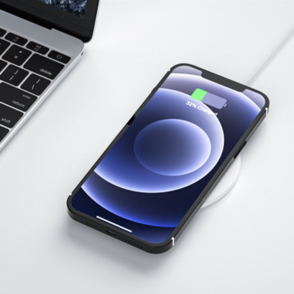 Ein schwarzes Telefon, das drahtlos auf einem weißen Ladepad aufgeladen wird.