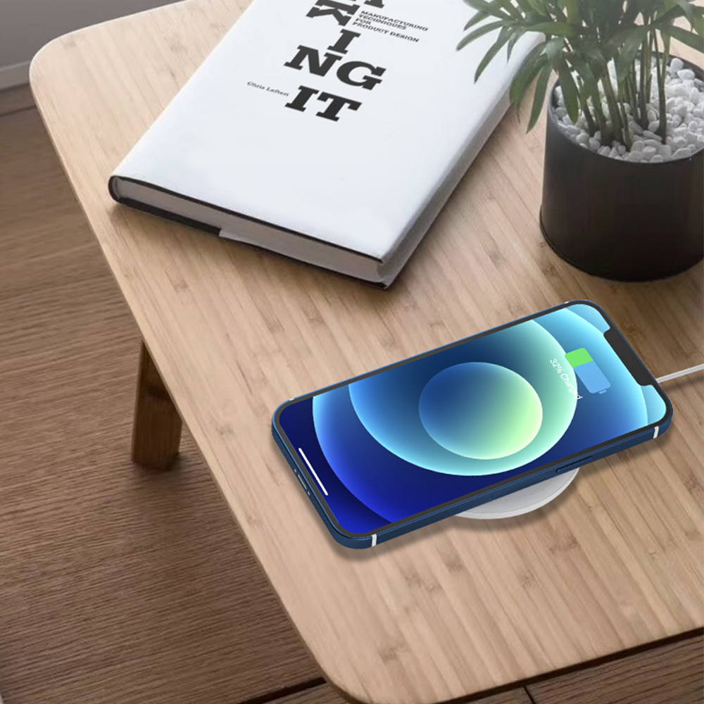 Ein Telefon, das auf einem kabellosen Ladegerät auf einem Holztisch geladen wird.