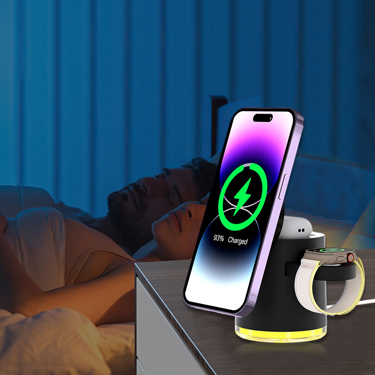 Ein Telefon und eine Uhr laden an einem schwarzen Ladeständer in der Nähe eines schlafenden Paares.