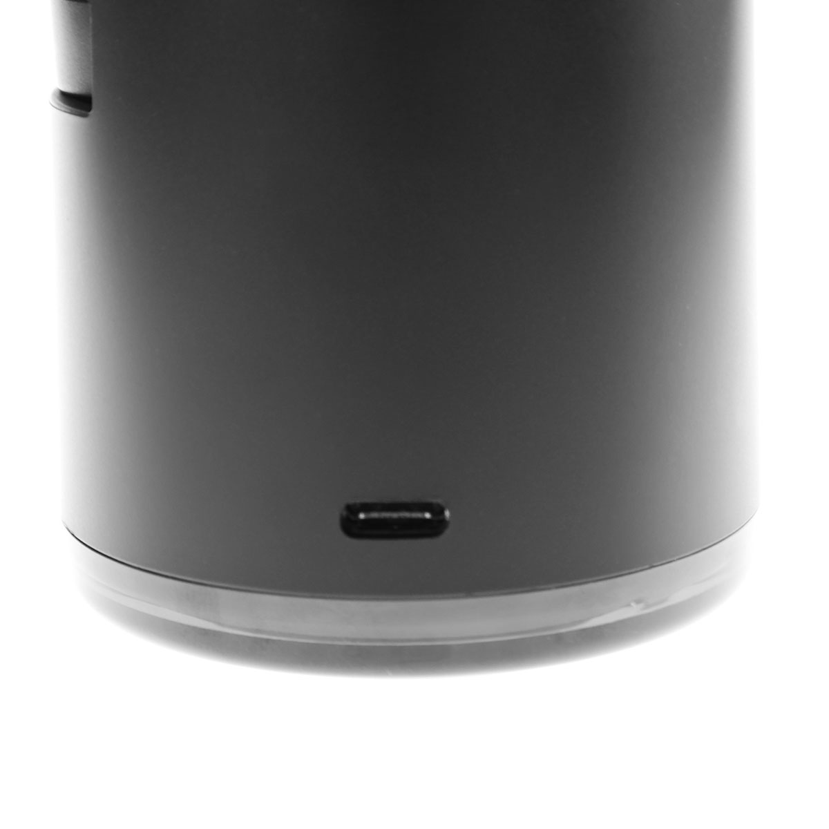 Eine Nahaufnahme einer schwarzen zylindrischen Ladestation, die den USB-C-Anschluss an der Basis zeigt, vor einem weißen Hintergrund.
