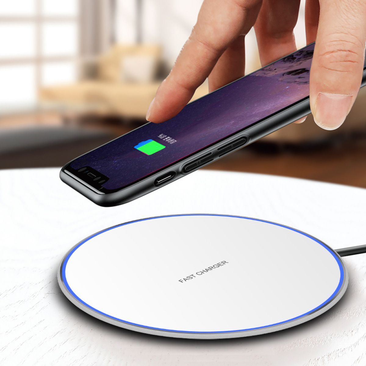 Eine Hand legt ein Telefon auf ein weißes, kabelloses Ladegerät mit blauem Ring auf einer Holzoberfläche.