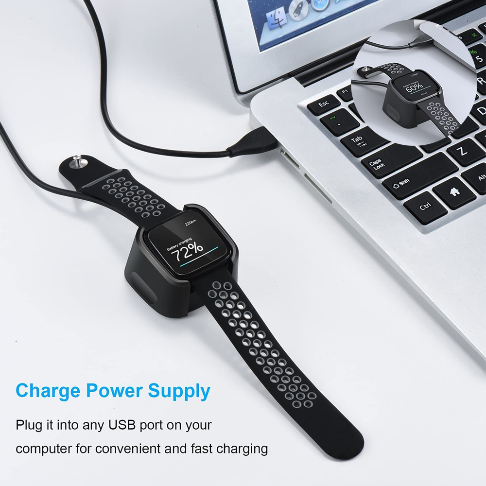 Eine Smartwatch wird auf einer Dockingstation aufgeladen, die mit einem Laptop verbunden ist und den Akkustand anzeigt.