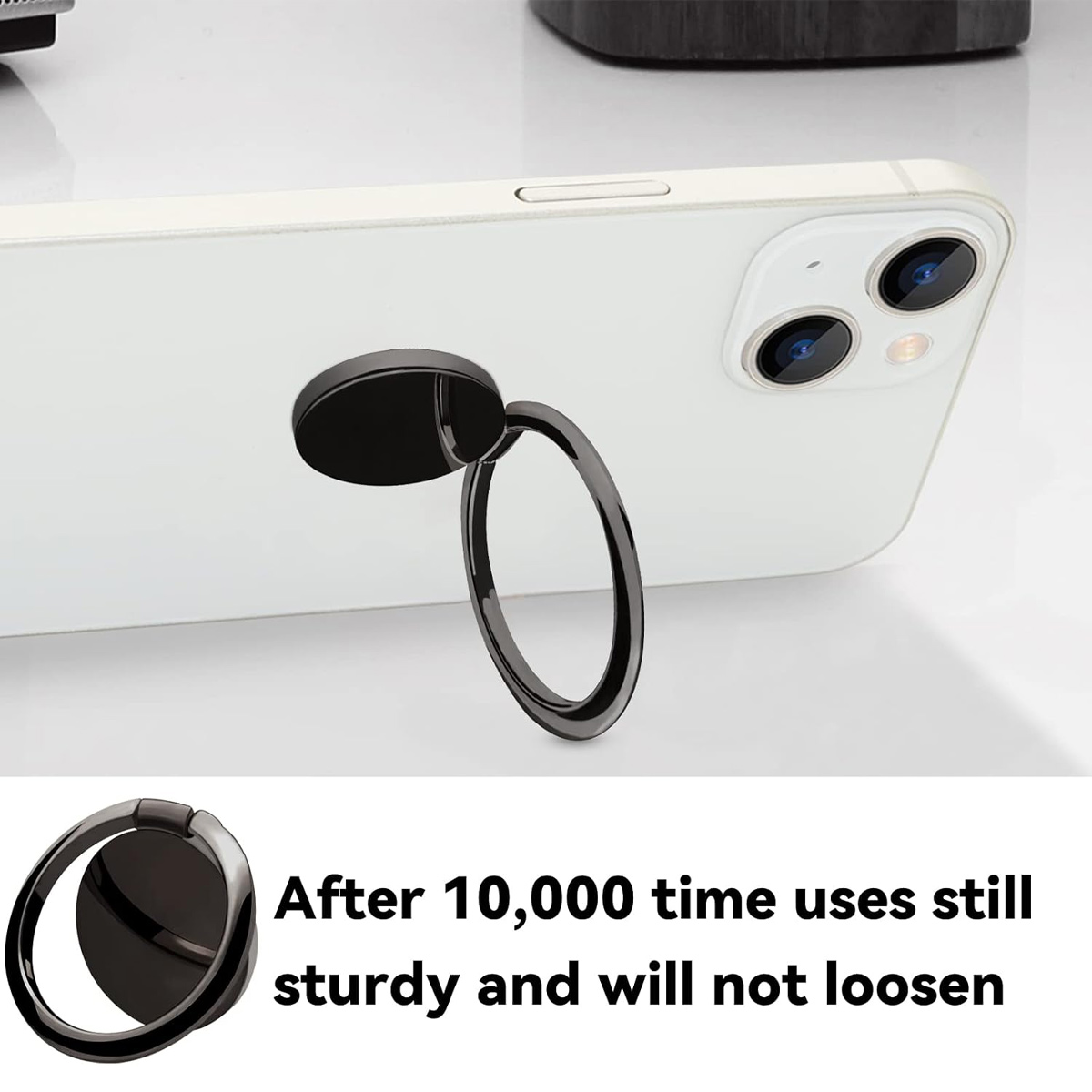 Nahaufnahme eines schwarzen Telefonringhalters, der an einem weißen Smartphone befestigt ist und in einem Winkel auf einer weißen Oberfläche gezeigt wird.