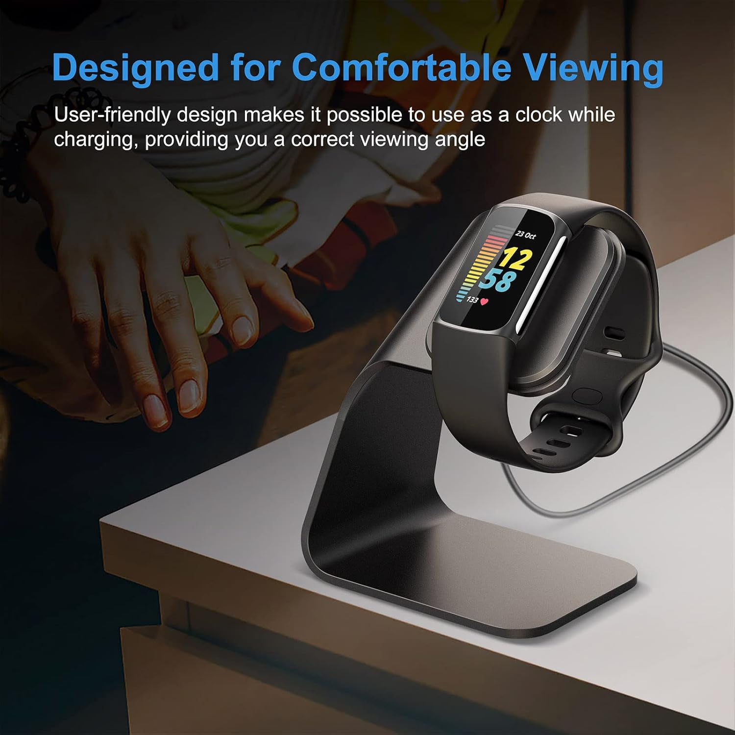 Ein schwarzer Fitnesstracker wird auf einem schwarzen Ständer auf einer weißen Oberfläche aufgeladen, der für eine komfortable Anzeige entwickelt wurde.
