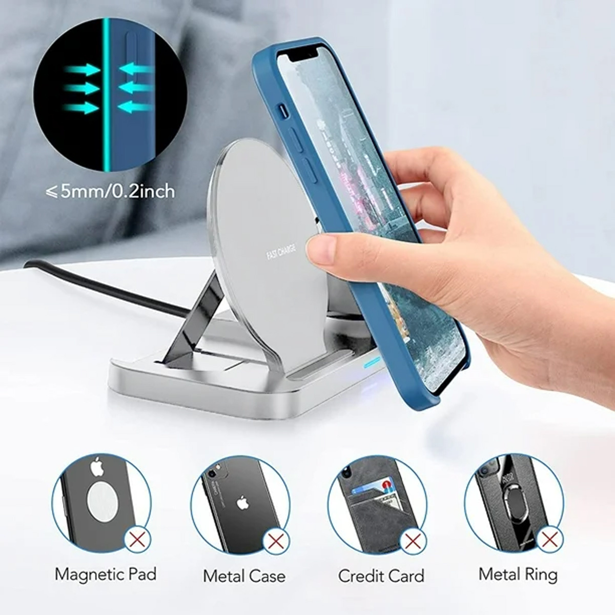 Eine Hand legt ein Telefon mit einer blauen Handyhülle auf einen silbernen kabellosen Ladeständer.