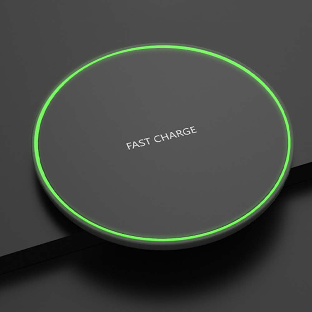 Ein schwarzes kabelloses Ladepad mit einem grünen Licht um den Rand und dem Text 'FAST CHARGE'.