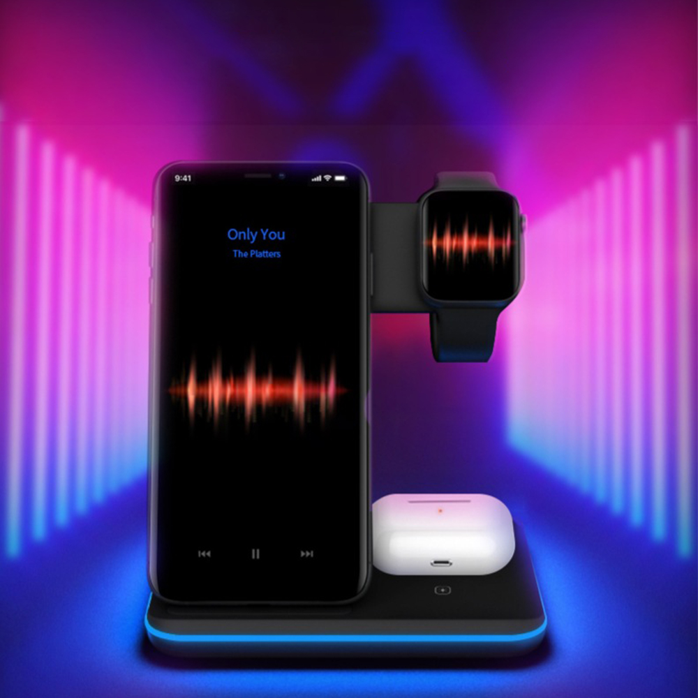 Schwarzes kabelloses Ladegerät mit Telefon, Uhr und Ohrhörern auf einem Ständer vor Neonlichtern.