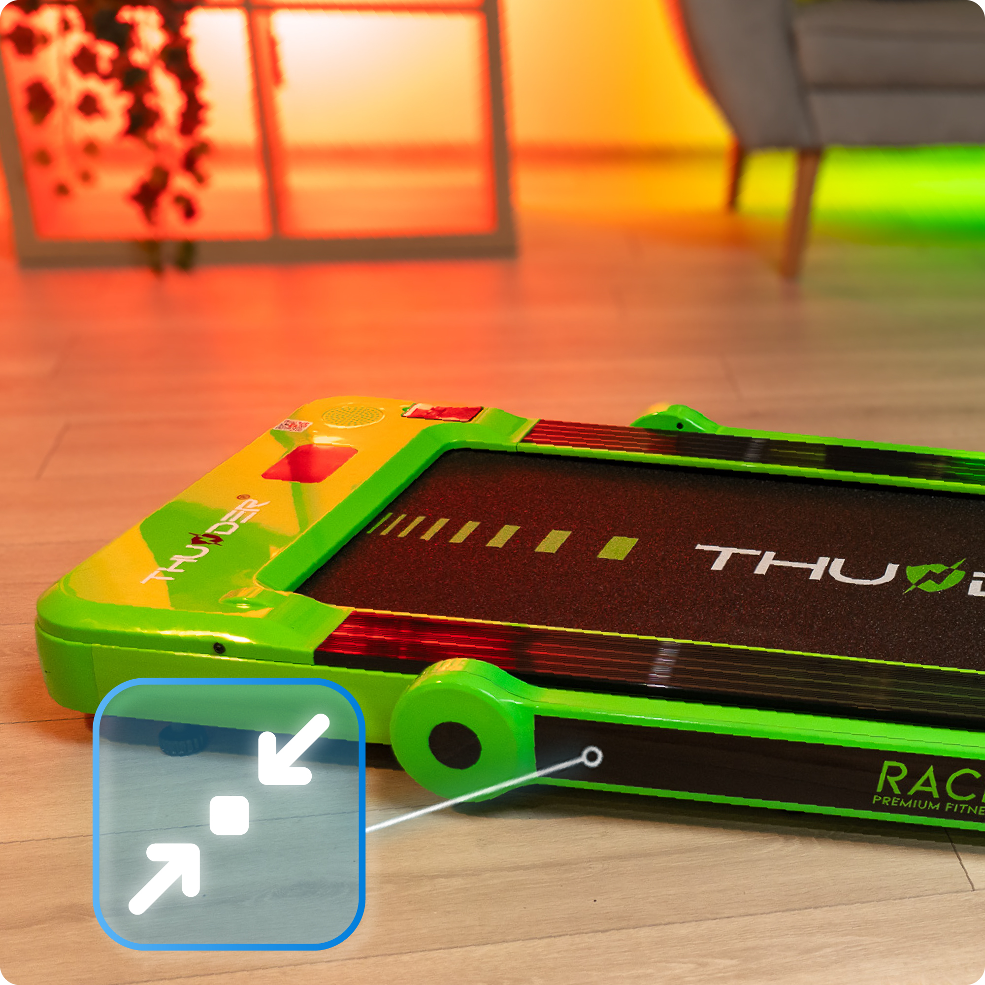 Zbliżenie zielonej bieżni z czarną powierzchnią do biegania. Strzałki wskazują funkcję składania.