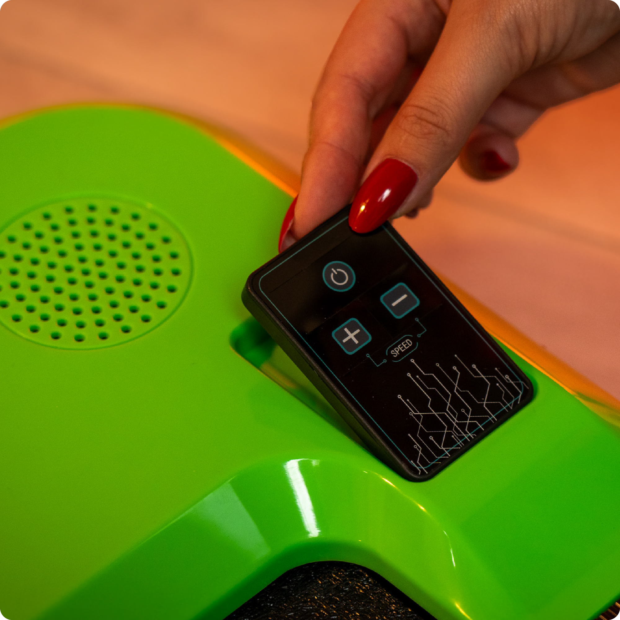 Zbliżenie dłoni trzymającej pilota. Bieżnia jest zielona.