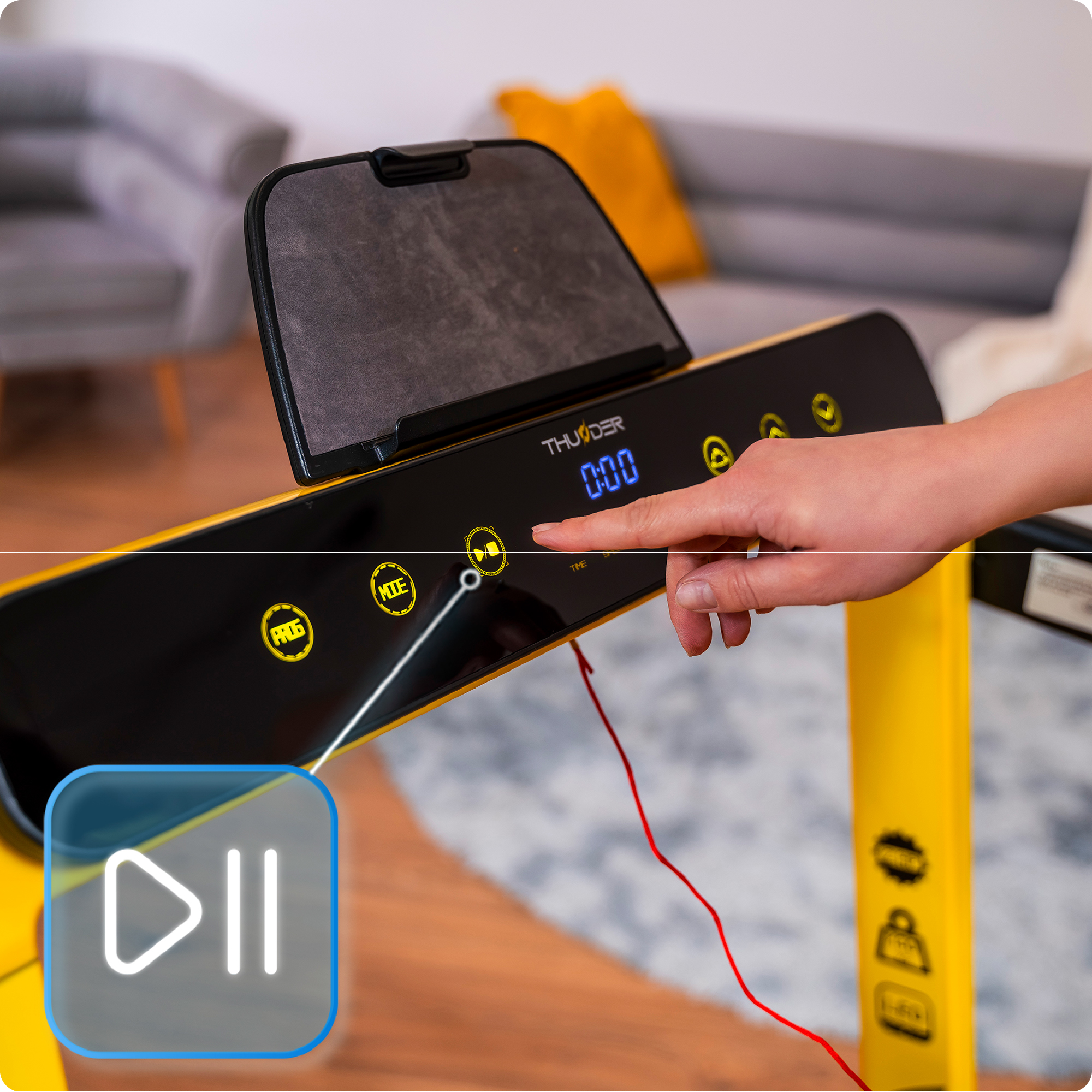 Dłoń osoby naciska przycisk na panelu sterowania żółtej bieżni w domowym otoczeniu.