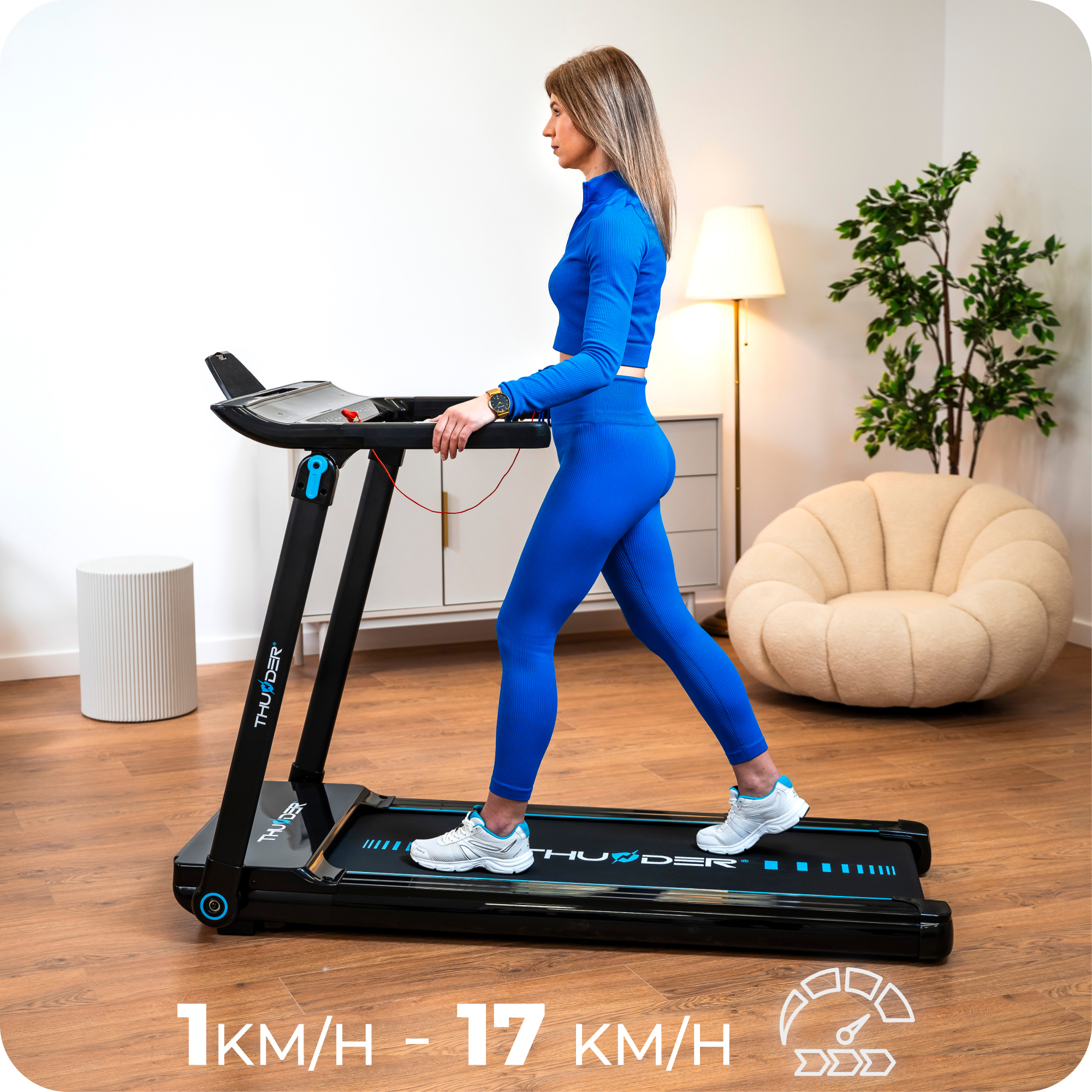 Kobieta chodzi po czarnej bieżni z niebieskimi akcentami, pokazując zakres prędkości od 1 km/h do 17 km/h.