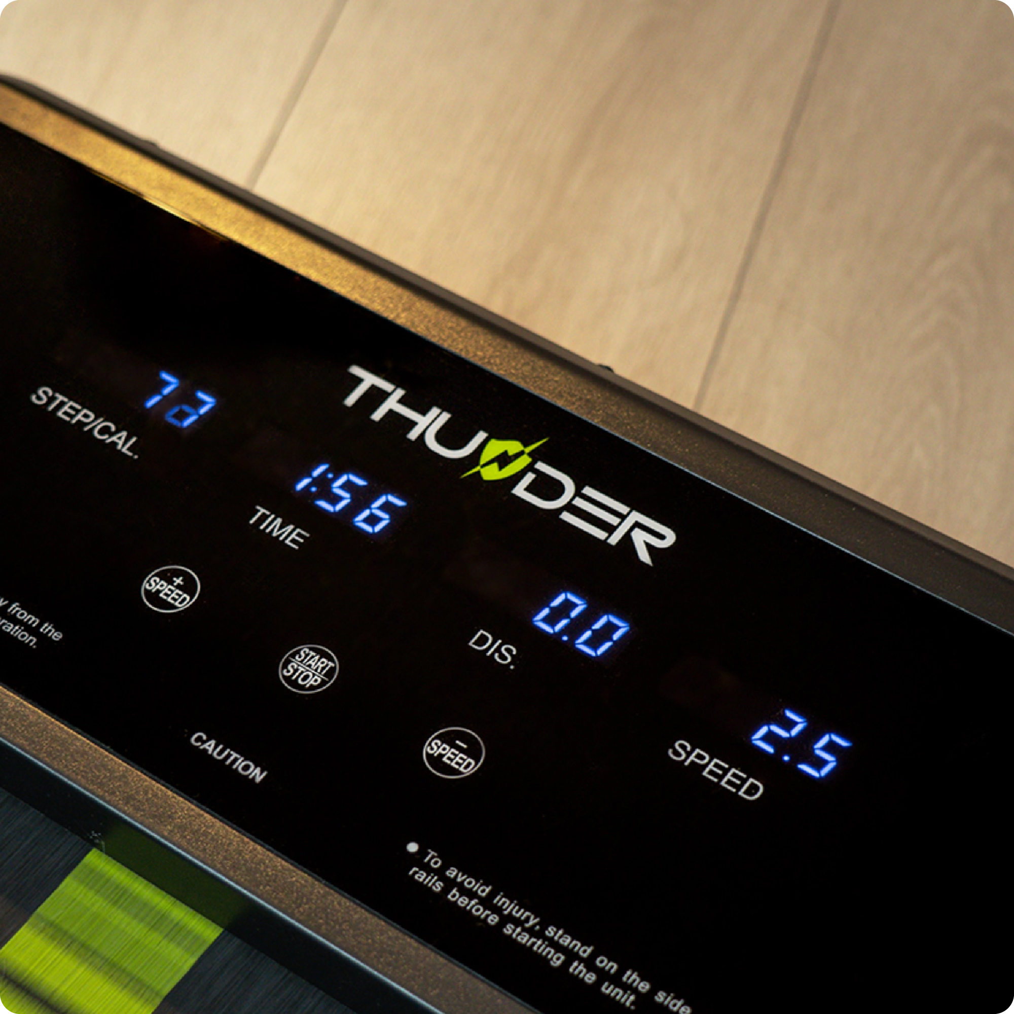 Zbliżenie konsoli bieżni wyświetlającej statystyki: Stepcal 73, Czas 1:56, Dystans 0,0 i Prędkość 2,5.