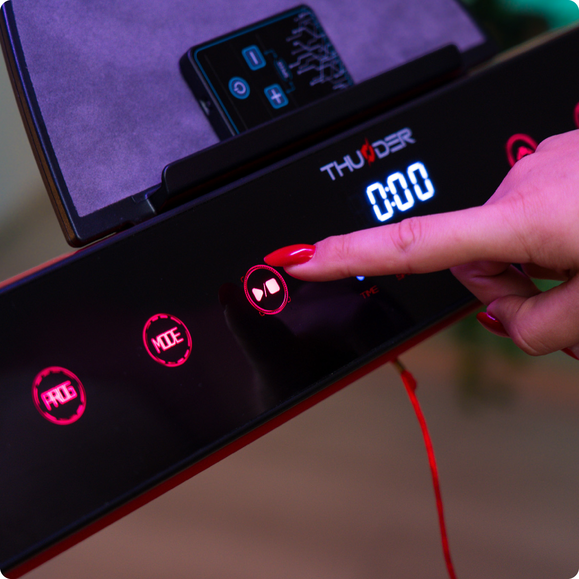 Dłoń naciskająca przycisk na konsoli bieżni, wyświetlająca timer i opcje sterowania.