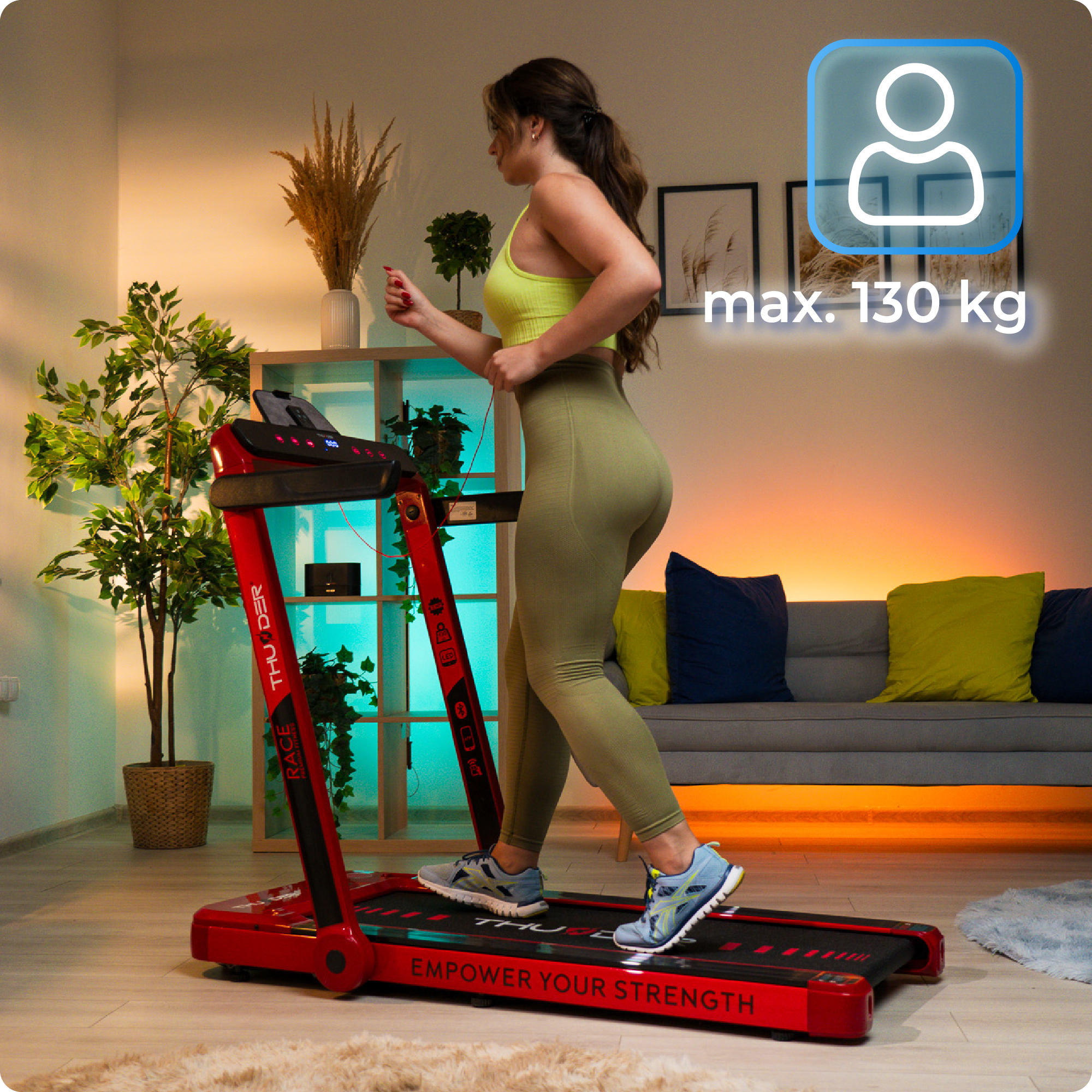 Kobieta biegnąca na czerwonej bieżni, ze wskaźnikiem limitu wagi i tłem pokoju.