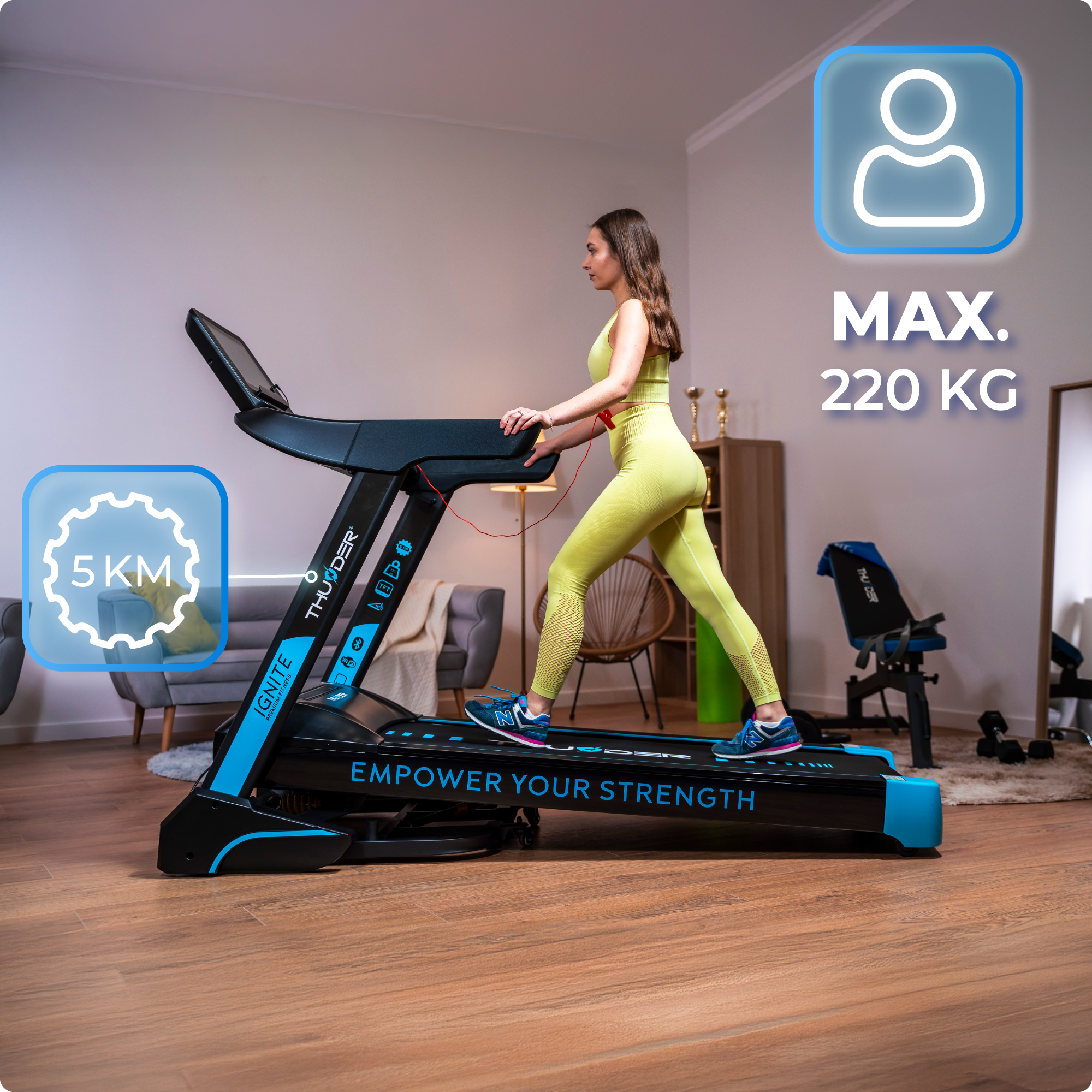 Kobieta idzie po niebiesko-czarnej bieżni o maksymalnej nośności 220 kg.