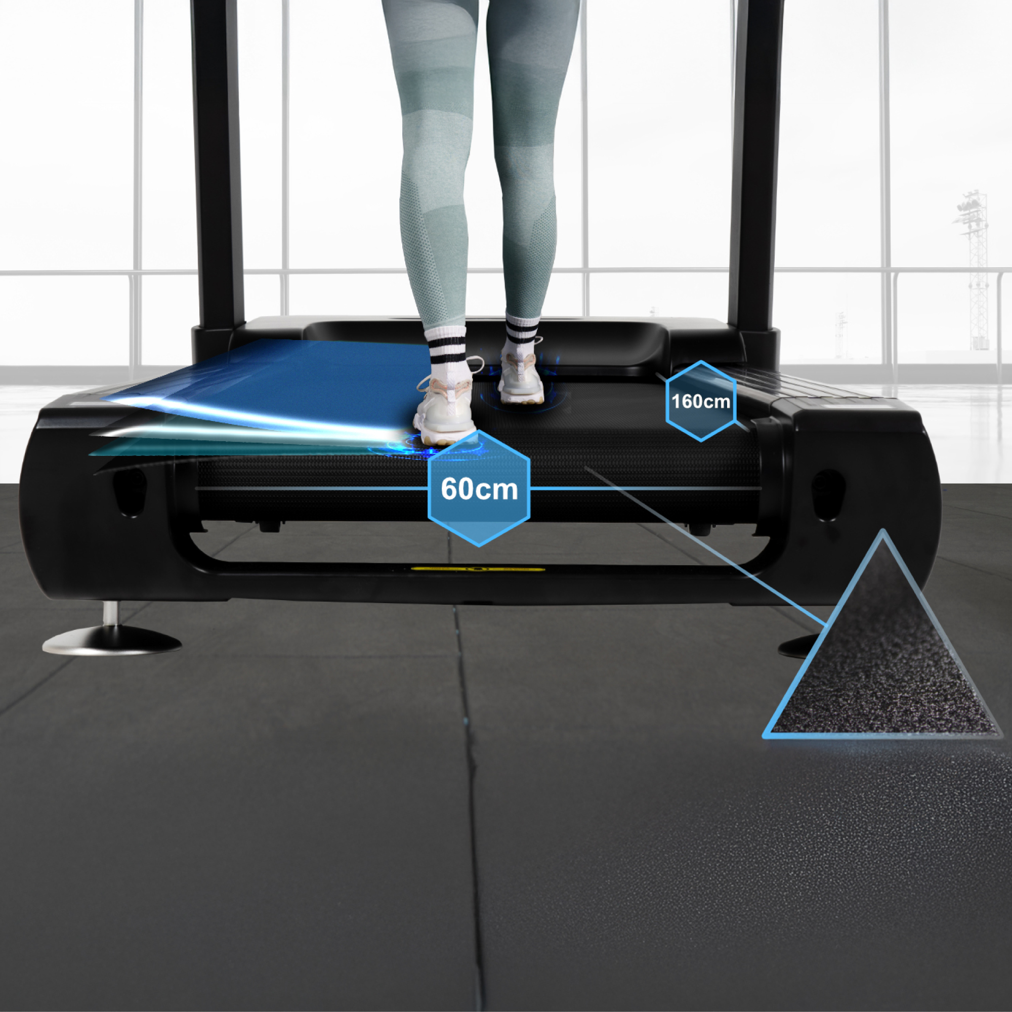 Czarna bieżnia przedstawia użytkownika chodzącego po niej, z niebieskimi liniami podkreślającymi wymiary, na tle jasnego okna.