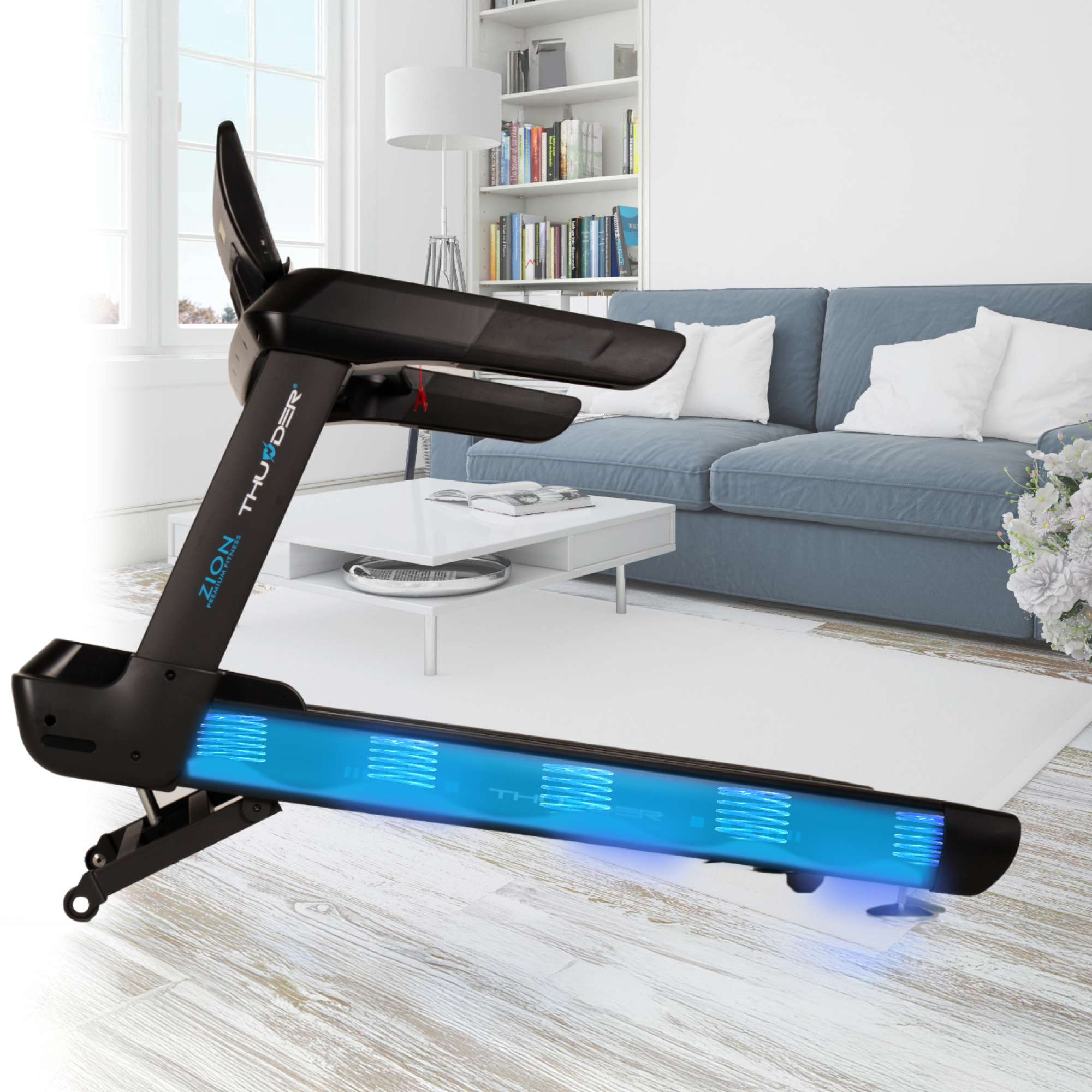 Czarna bieżnia z niebieskimi światłami znajduje się w salonie z niebieską kanapą, białym dywanem i białym stolikiem kawowym.