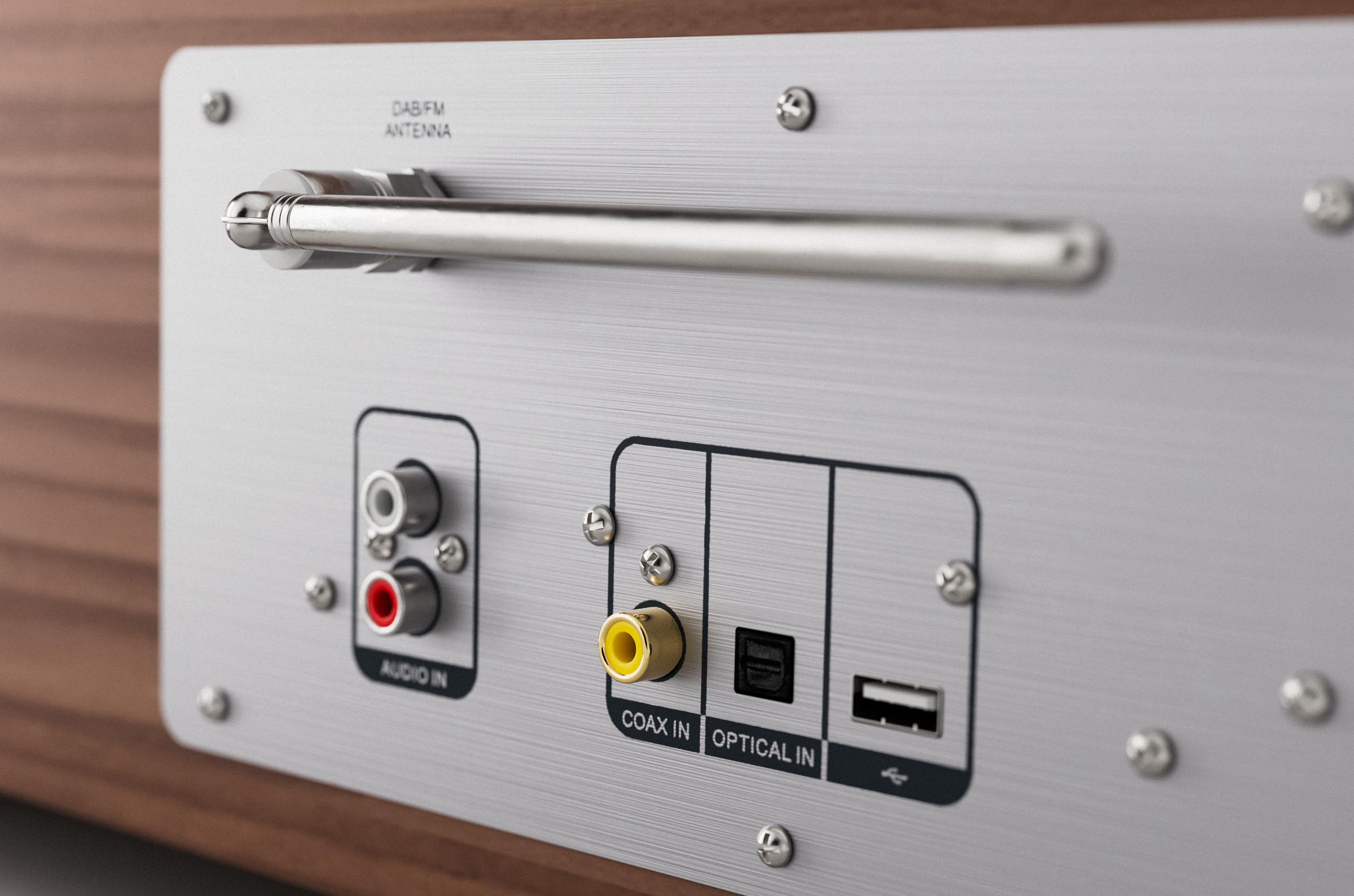 Close-up of the back of a stereo system with audio and coaxial inputs, and an antenna.