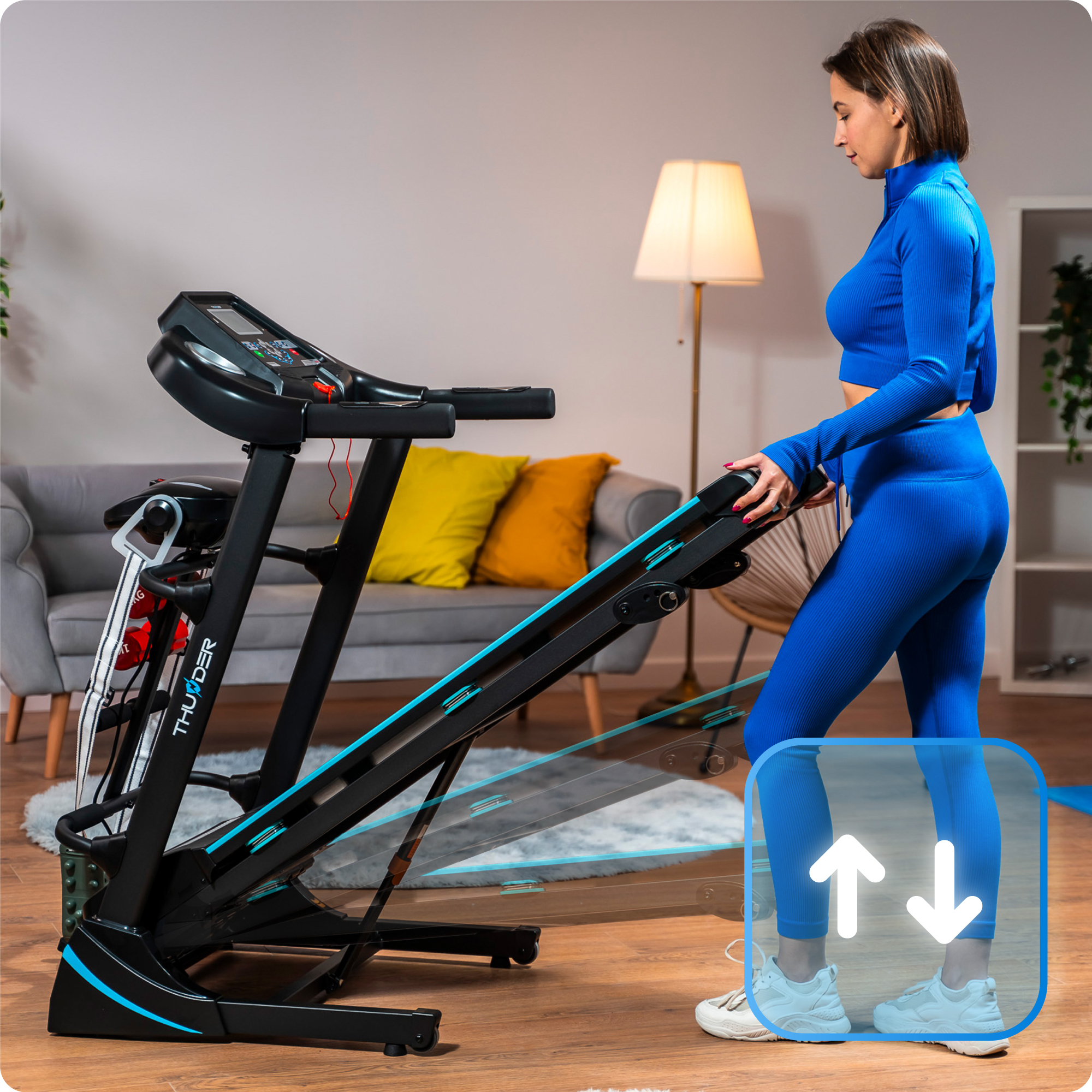 Kobieta w niebieskim stroju do ćwiczeń regulująca nachylenie na czarnej bieżni z niebieskimi akcentami.