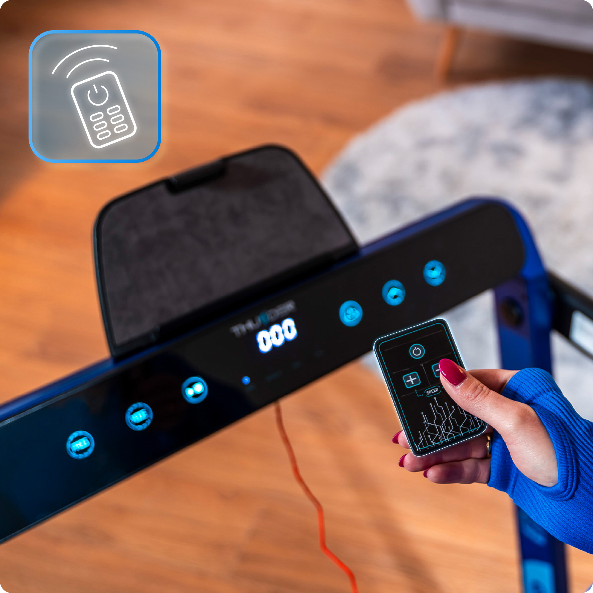 Osoba używa pilota w pobliżu ekranu bieżni.