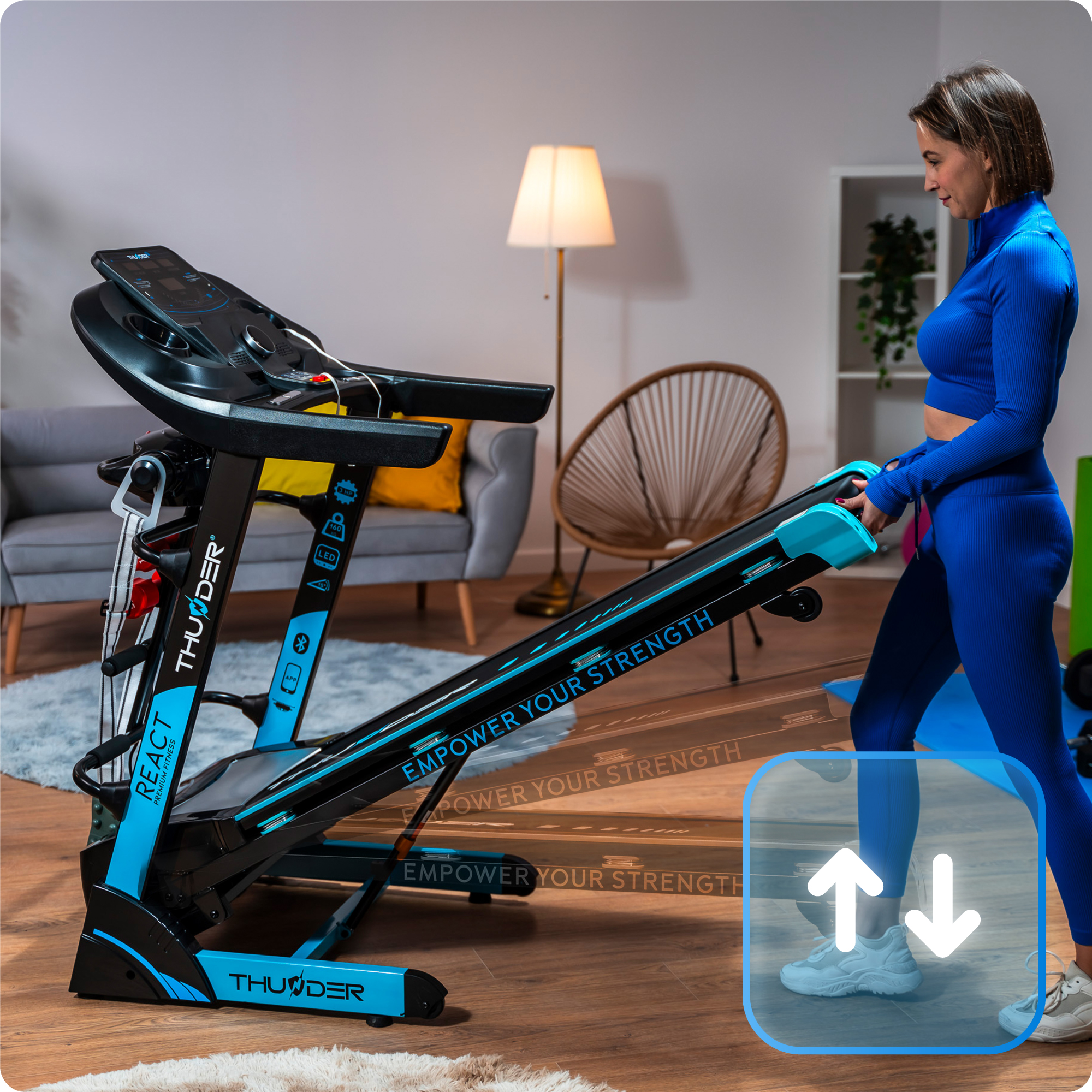 Kobieta w niebieskim stroju na czarno-niebieskiej bieżni w salonie, prezentująca sprzęt fitness i do ćwiczeń w domu.