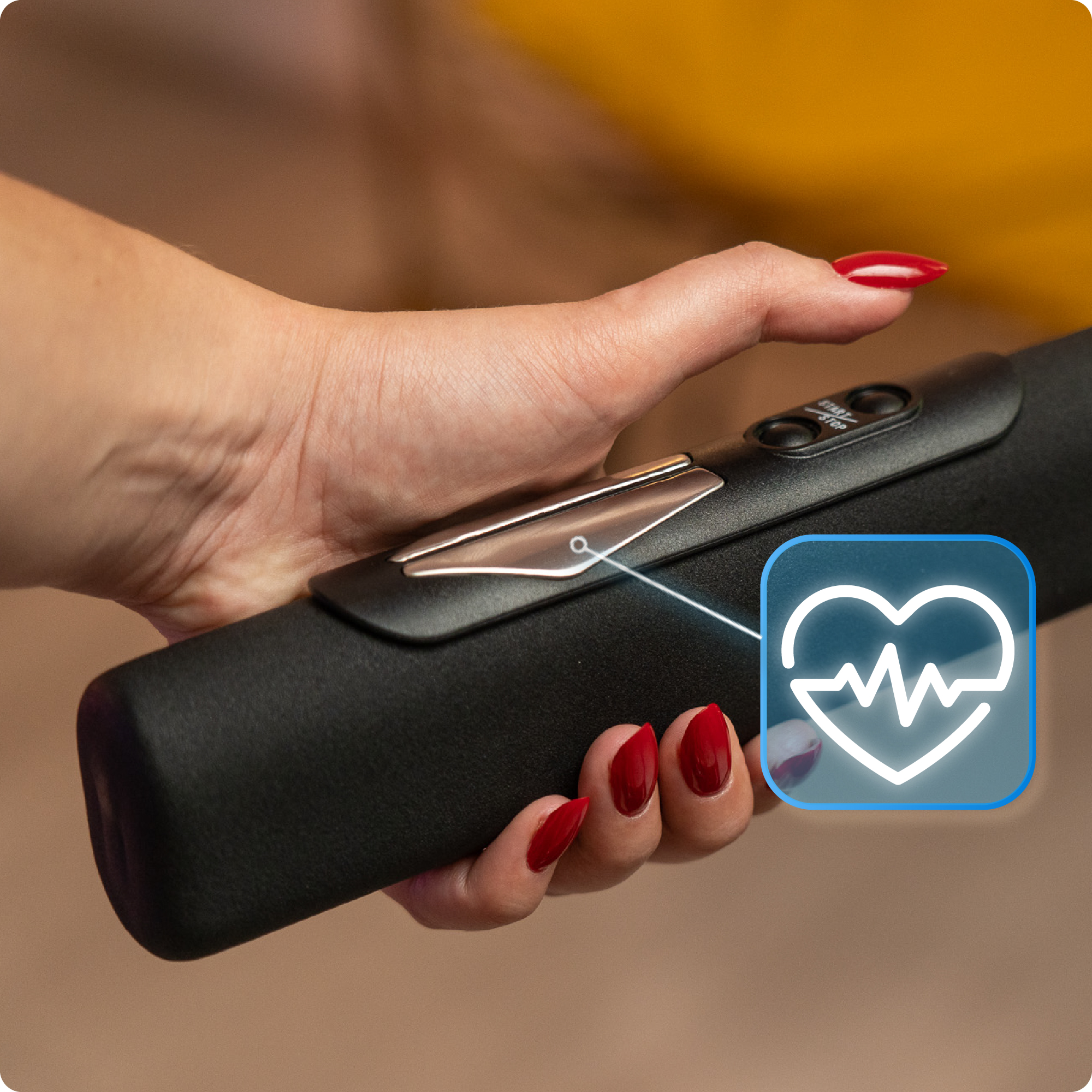 Ręka z czerwonymi paznokciami trzyma uchwyt bieżni z ikoną tętna.