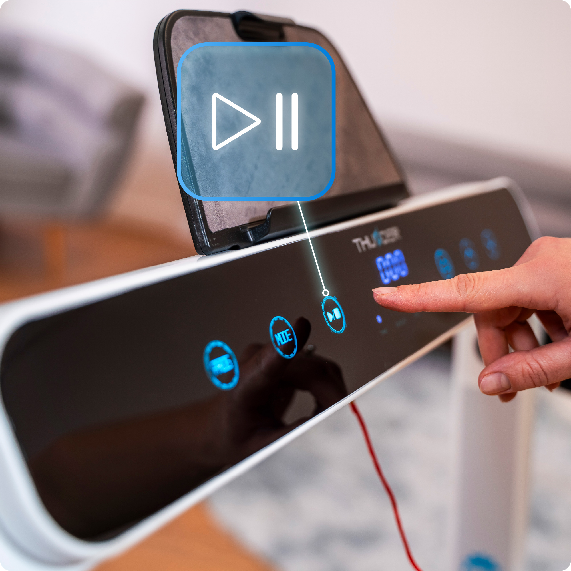 Osoba naciska przycisk odtwarzania na bieżni. Ikona odtwarzania w górnym rogu.