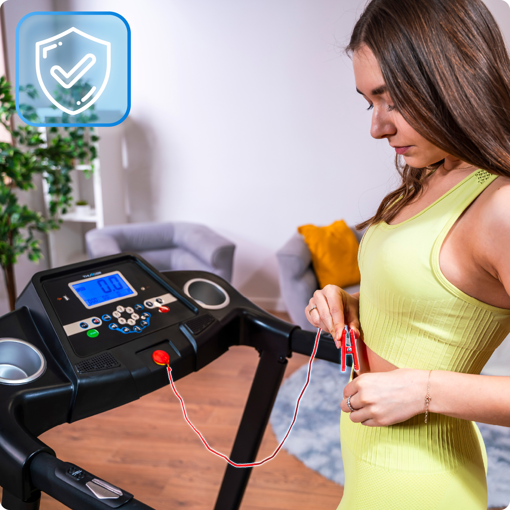 Obraz przedstawia kobietę przypinającą klips bezpieczeństwa do koszuli na bieżni Thunder w domowym otoczeniu.