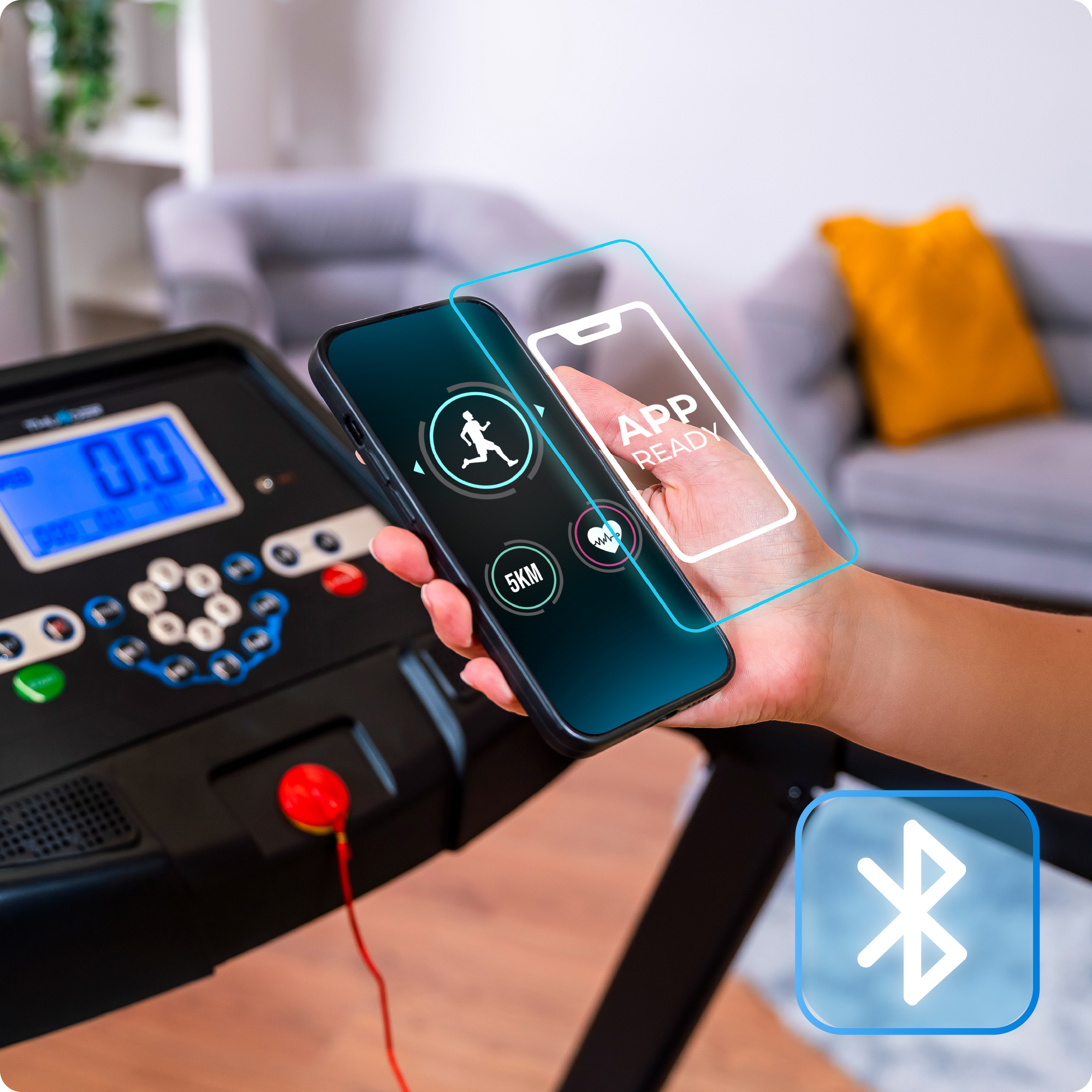 Obraz przedstawia telefon trzymany w pobliżu konsoli bieżni Thunder, podkreślając łączność z aplikacją i funkcje Bluetooth.