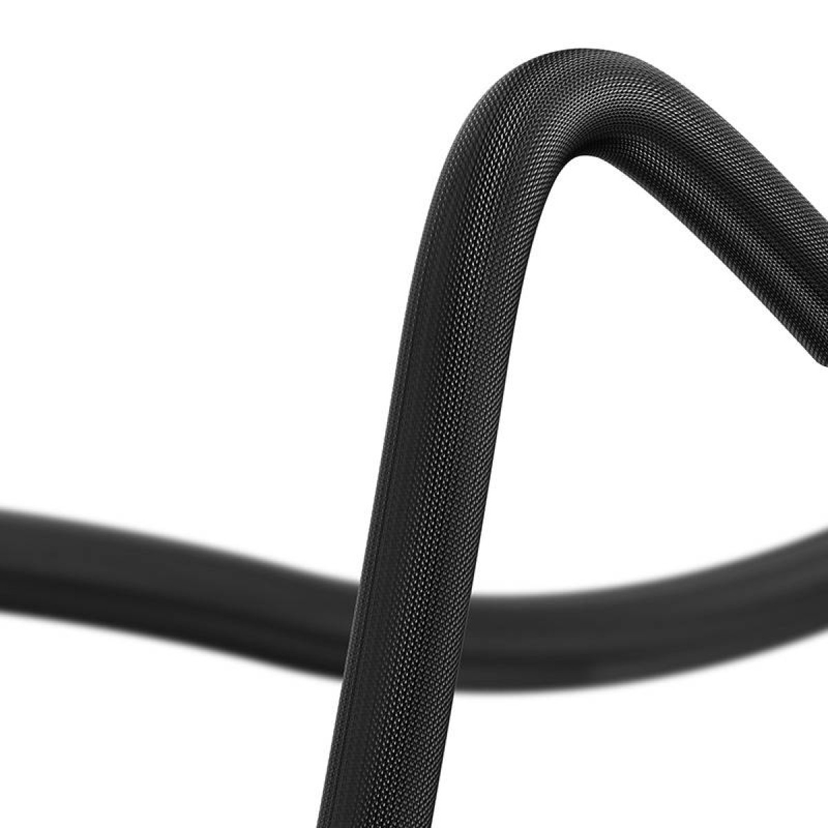 Zbliżenie czarnego kabla, zakrzywionego, teksturowanej powierzchni na tle bieli. Skupienie na fakturze.