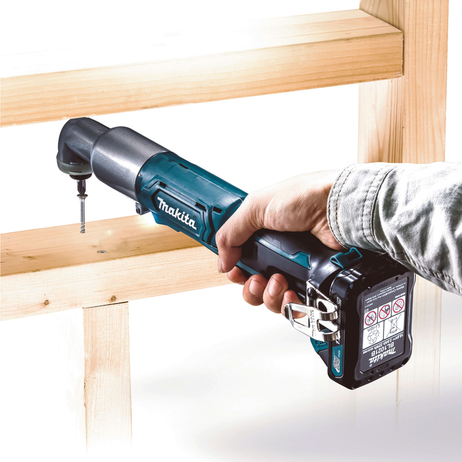 Se está utilizando un taladro Makita turquesa y negro para atornillar un tornillo en una viga de madera.