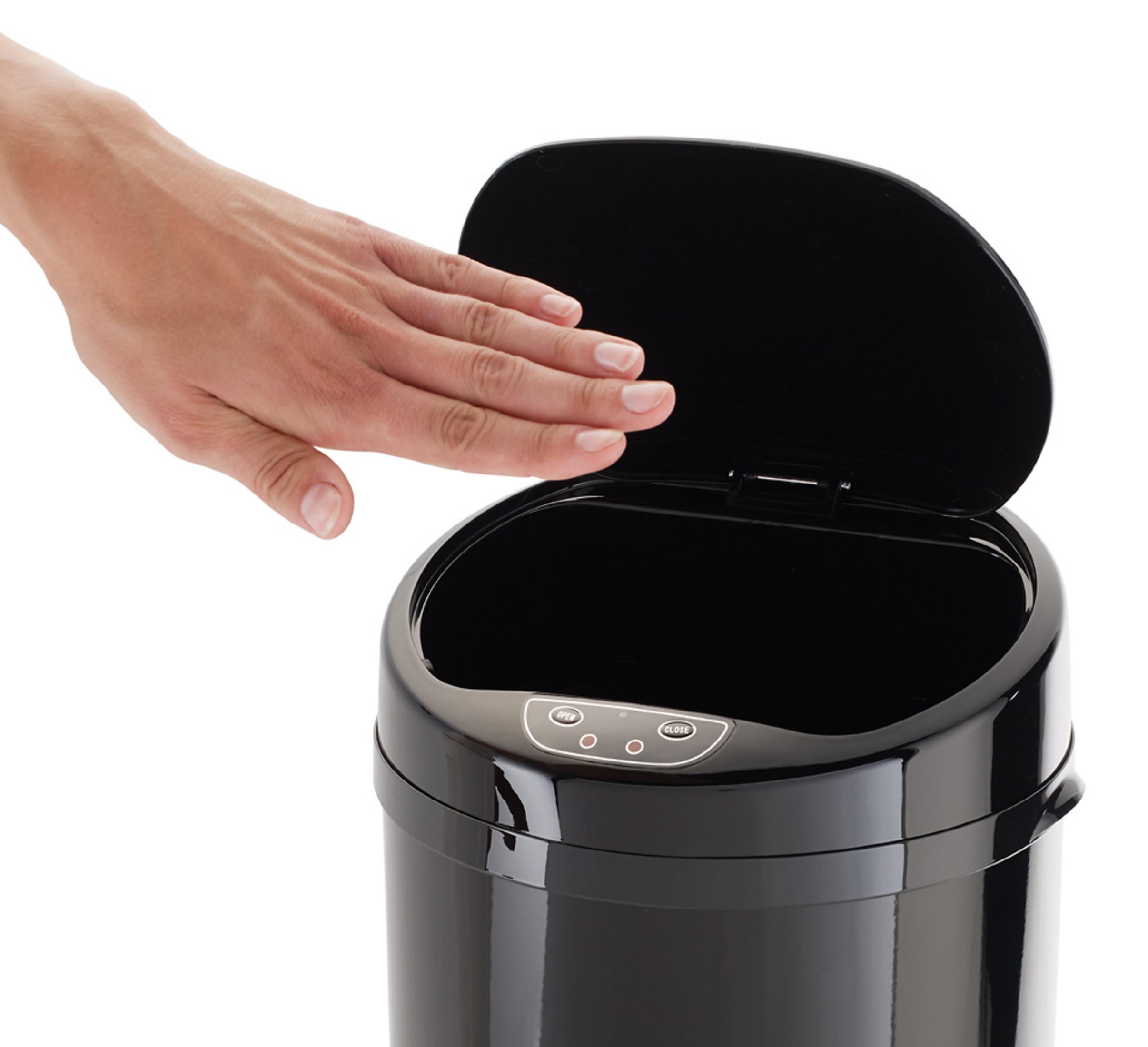 Ein schwarzer Mülleimer mit Deckel, der von einer Hand auf einem weißen Hintergrund geöffnet wird.