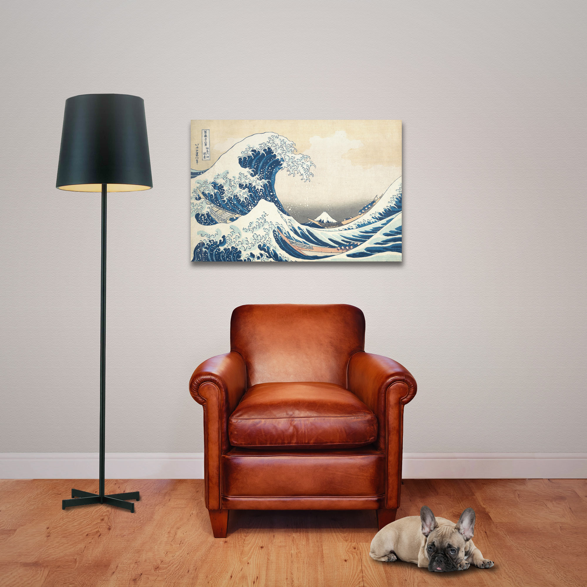 Ein Kunstwerk einer großen Welle hängt über einem Ledersessel, neben einer Stehlampe und einem Hund auf einem Holzboden.