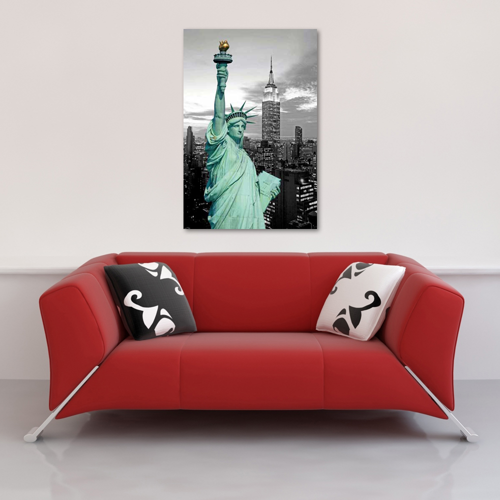Ein rotes Sofa mit Kissen unter einem Poster der Freiheitsstatue und des Empire State Buildings.