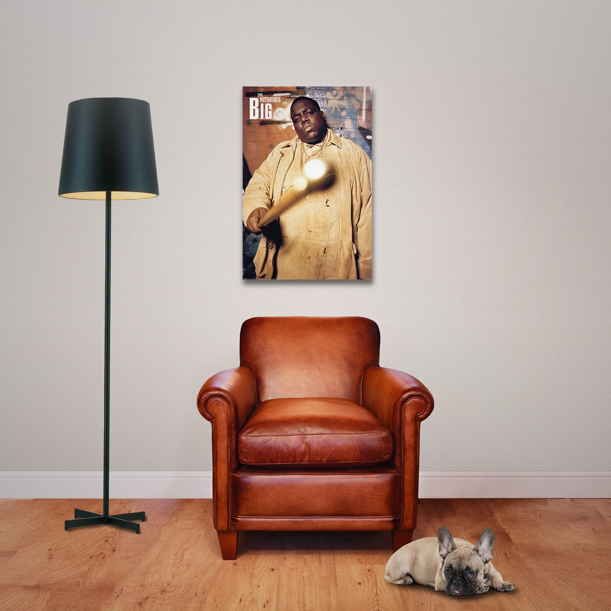 Ein Poster von Notorious B.I.G. hängt über einem Ledersessel mit einem Hund und einer Lampe in einem gemütlichen Raum.