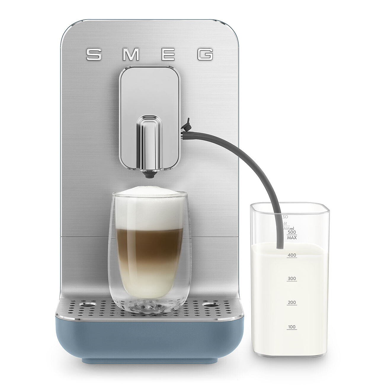 Cafetera SMEG azul sirviendo un café con leche en un vaso, con un recipiente de leche cerca.