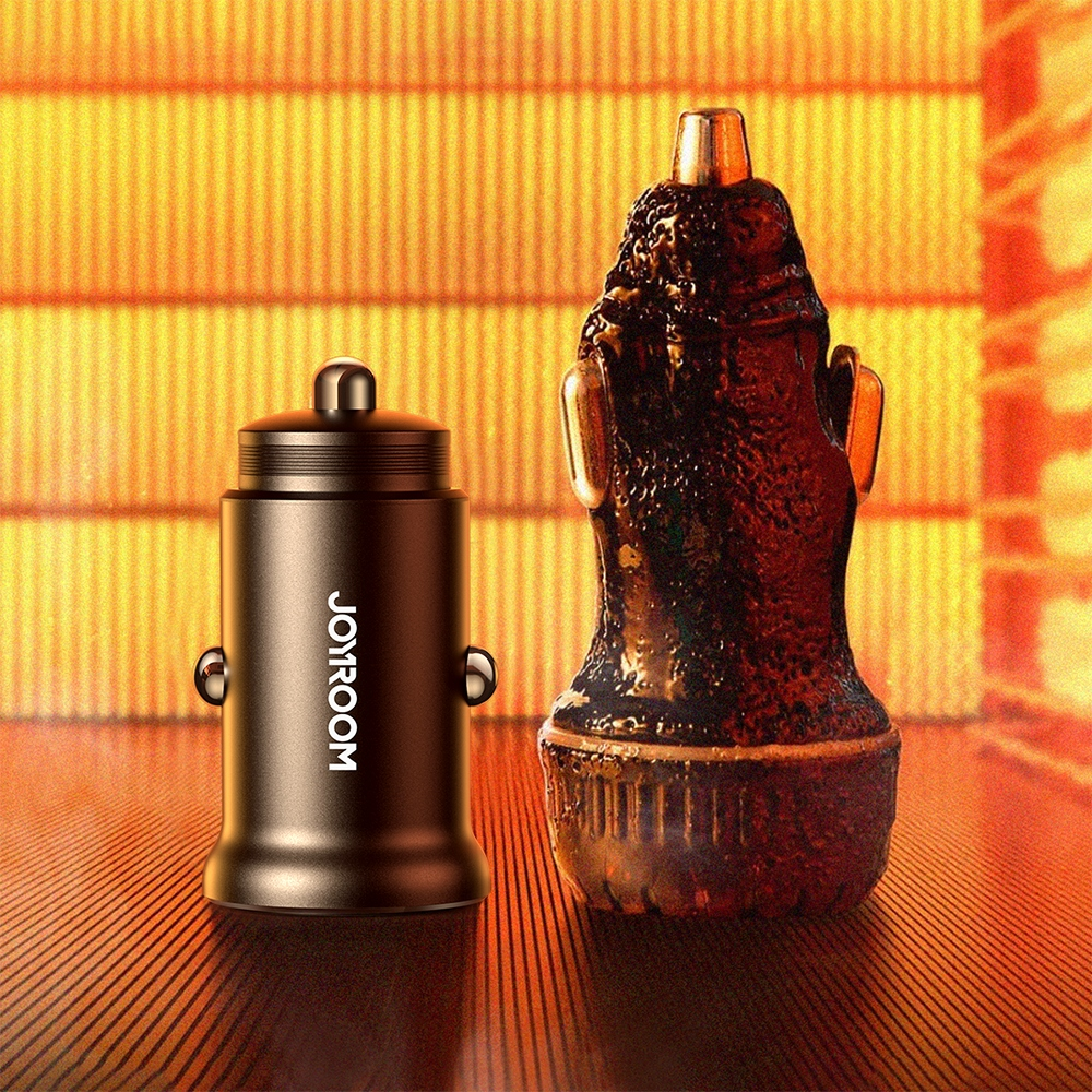 Dwie ładowarki samochodowe, jedna oznaczona jako JOYROOM, wyświetlane na pomarańczowym tle. Jedna jest elegancka, druga ozdobna.