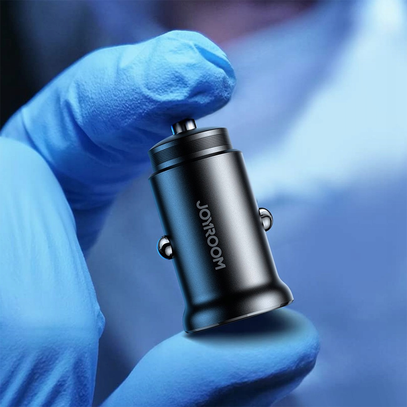 Ładowarka samochodowa Joyroom trzymana w rękawicy, podkreślająca jej kompaktową konstrukcję.